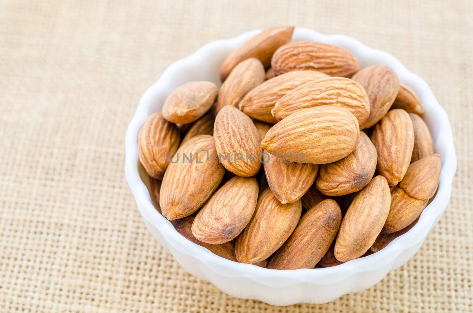 Almonds in white cup. by Gamjai