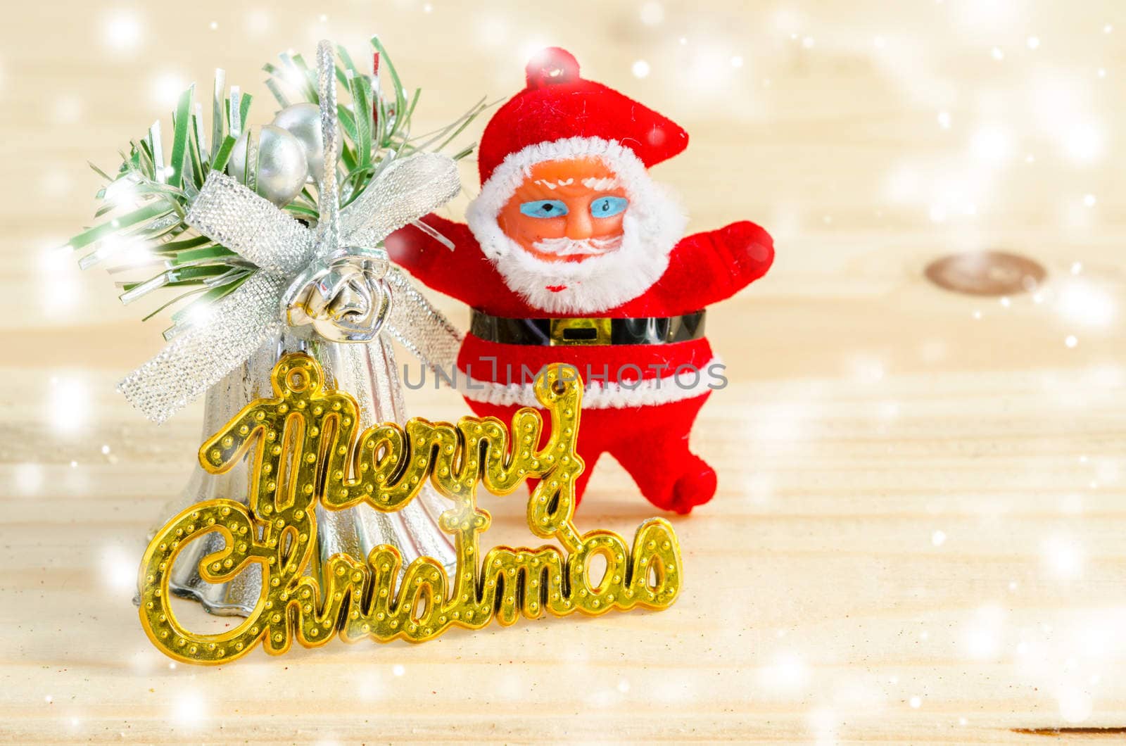 Merry christmas wording and santa doll with snow on wood background.