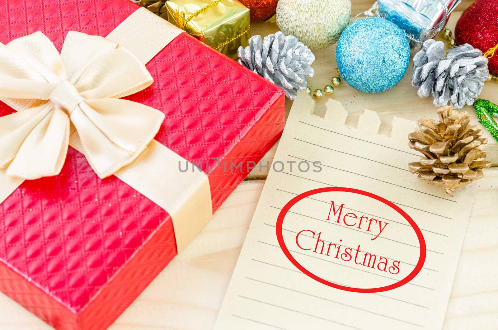 Merry Christmas word writing on brown paper with christmas decorations on wooden background.