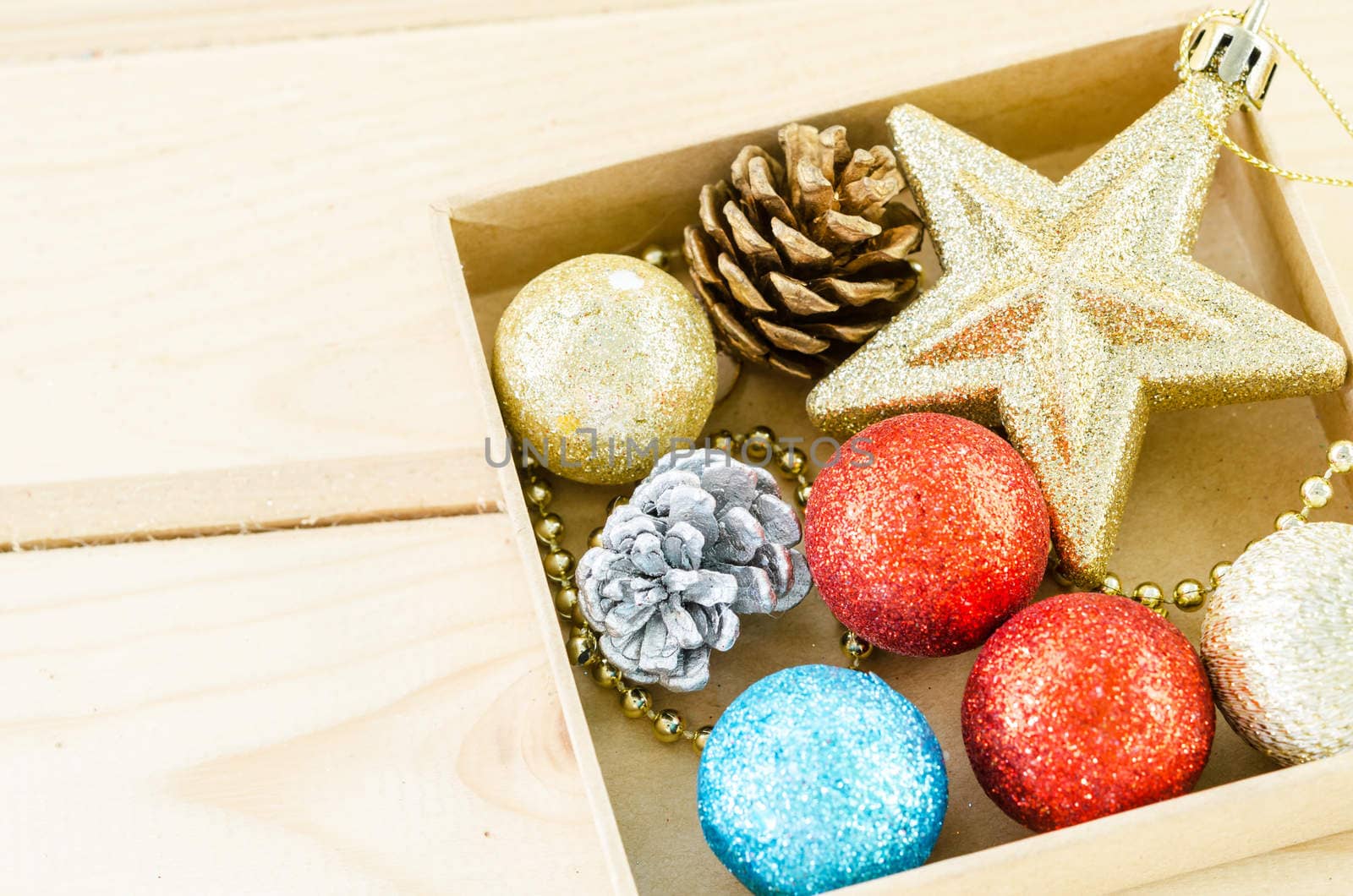 Christmas decorations in box on wooden background.