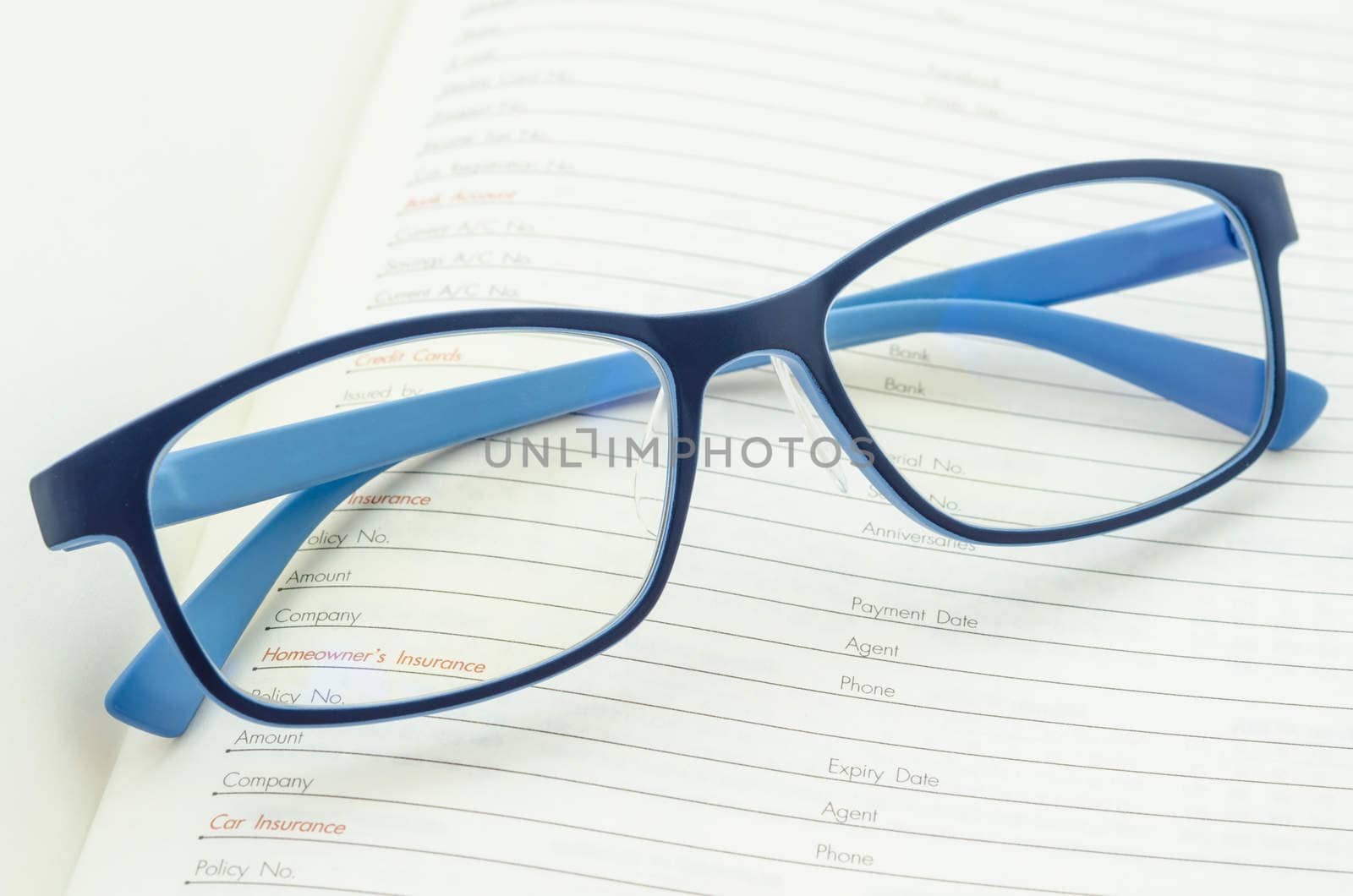 Eyeglasses on open diary planner. by Gamjai