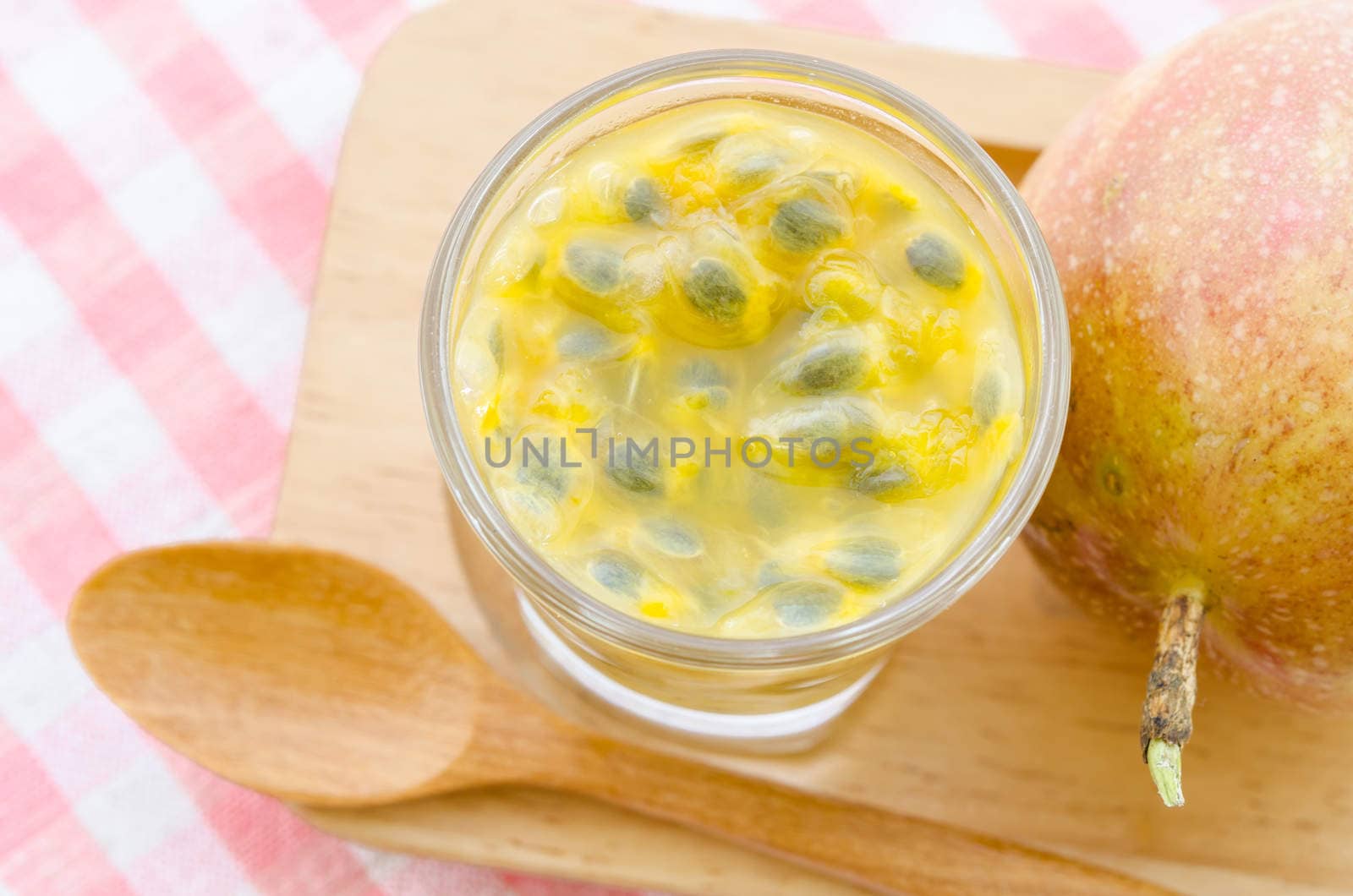 Passion fruit in glass on tablecloth.