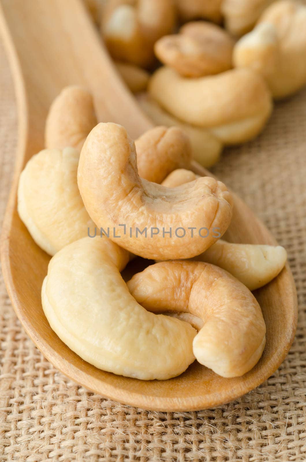 Roasted cashews on natural wooden table background