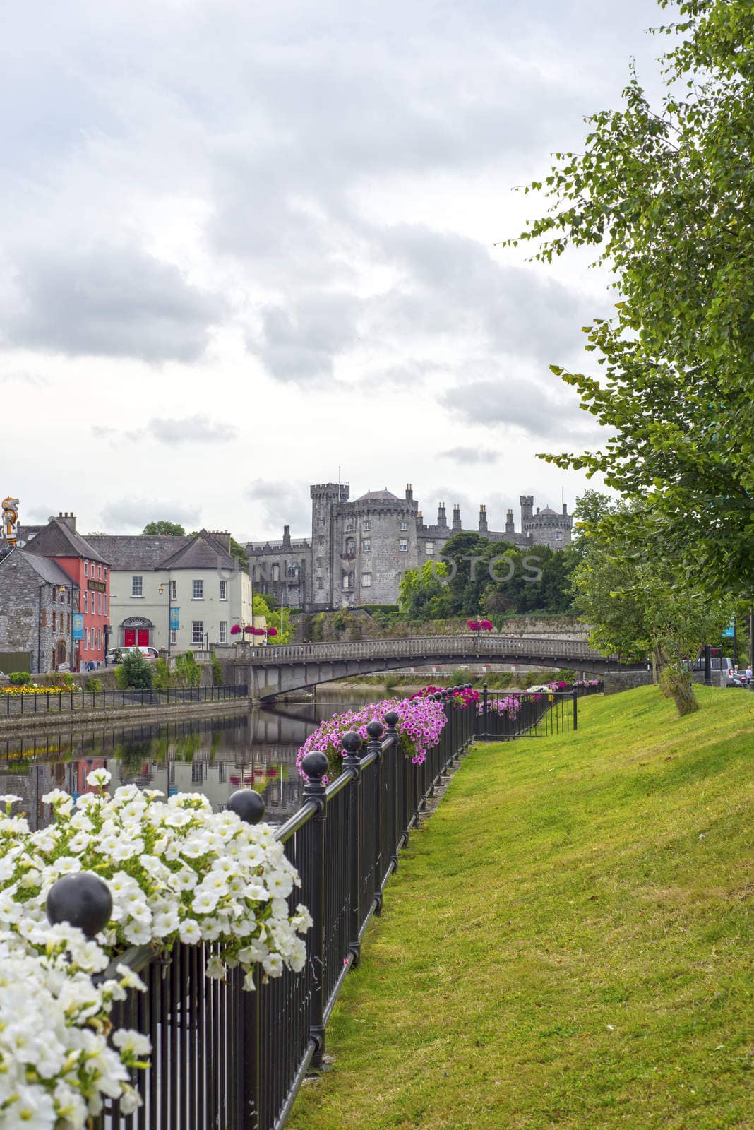 beautiful flower lined riverside view of kilkenny castle and bridge