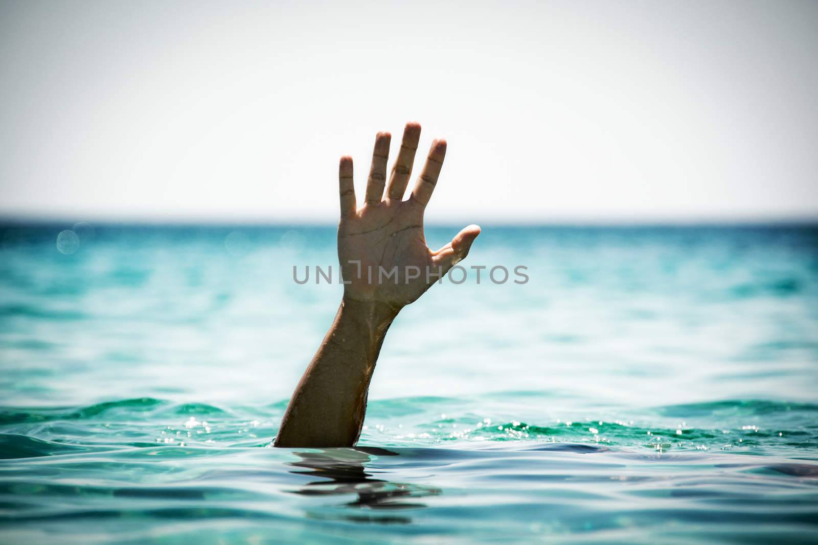 Single hand of drowning man in sea asking for help