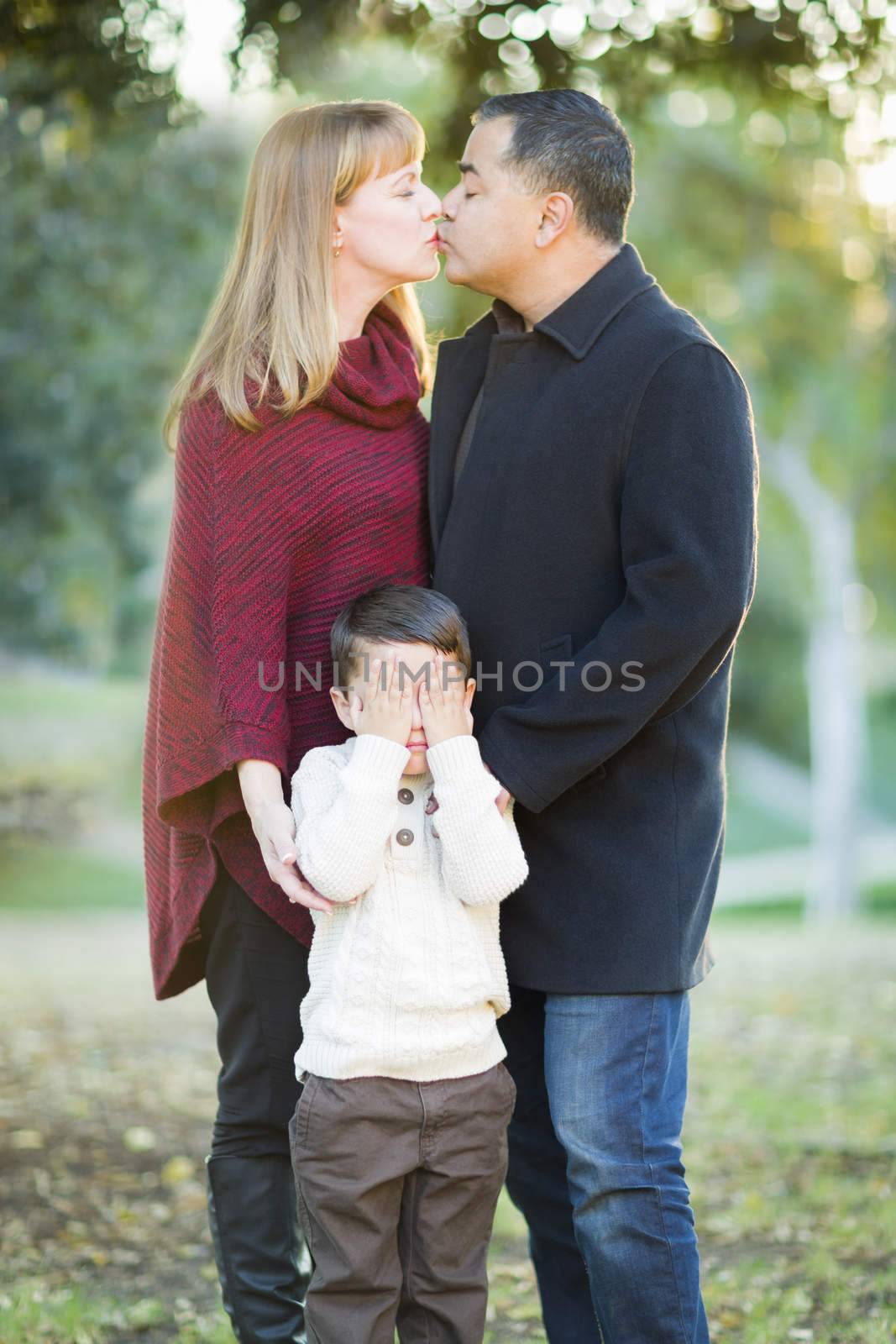 Loving Mix Race Couple Kissing As Young Son Hides His Eyes.