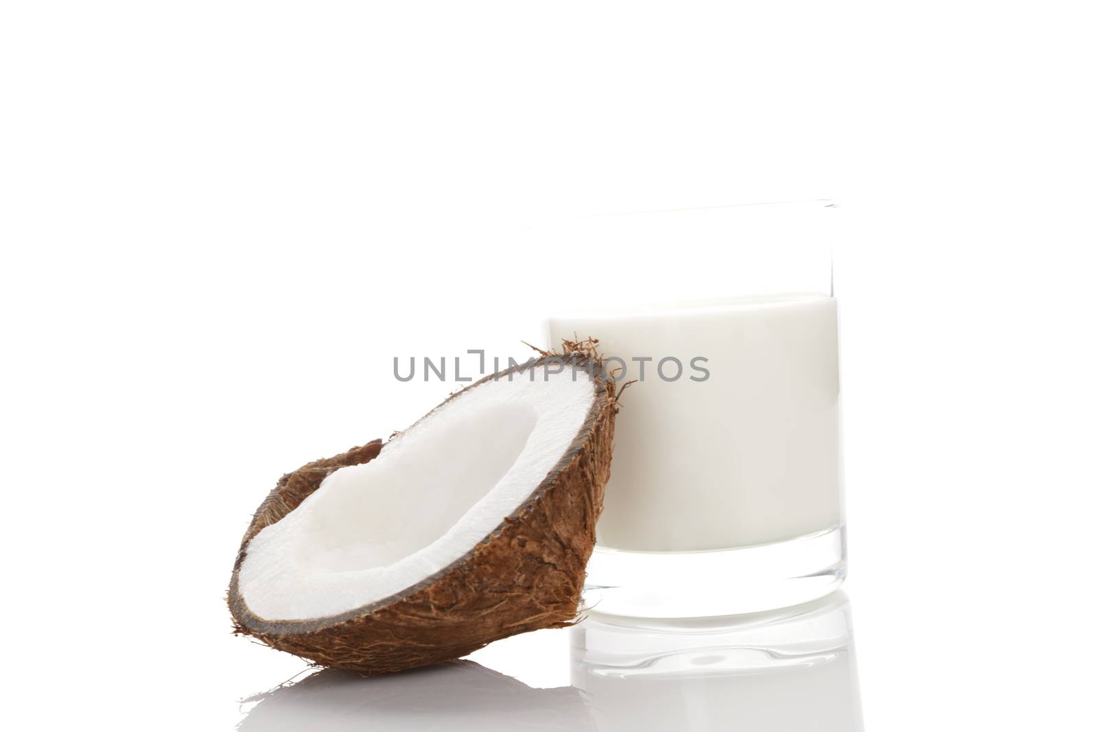 Coconut milk in glass and cracked coconut isolated on white background. Vegan milk. 