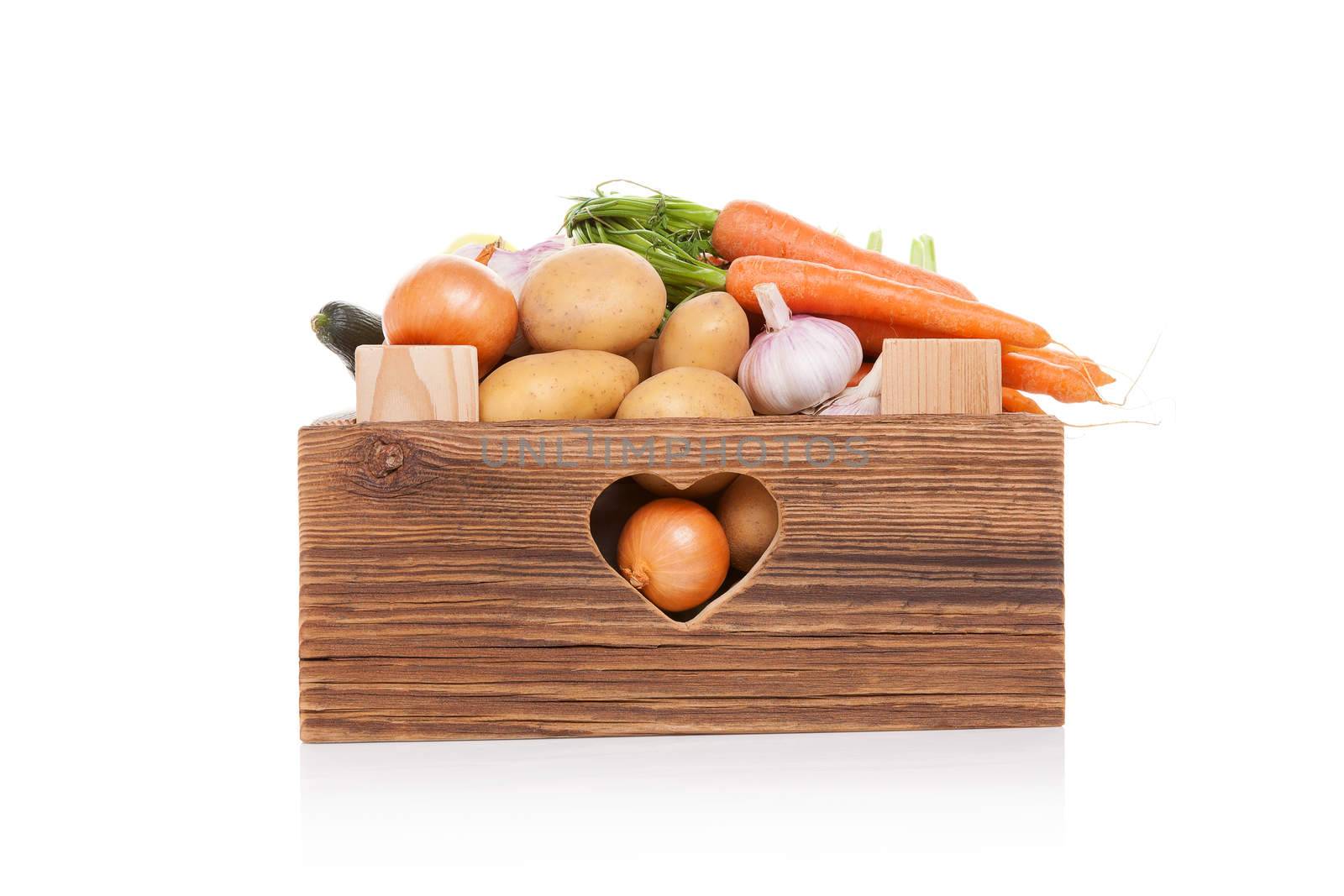Organic seasonal vegetable in rustic wooden crate isolated on white background. Healthy vegetable eating. 