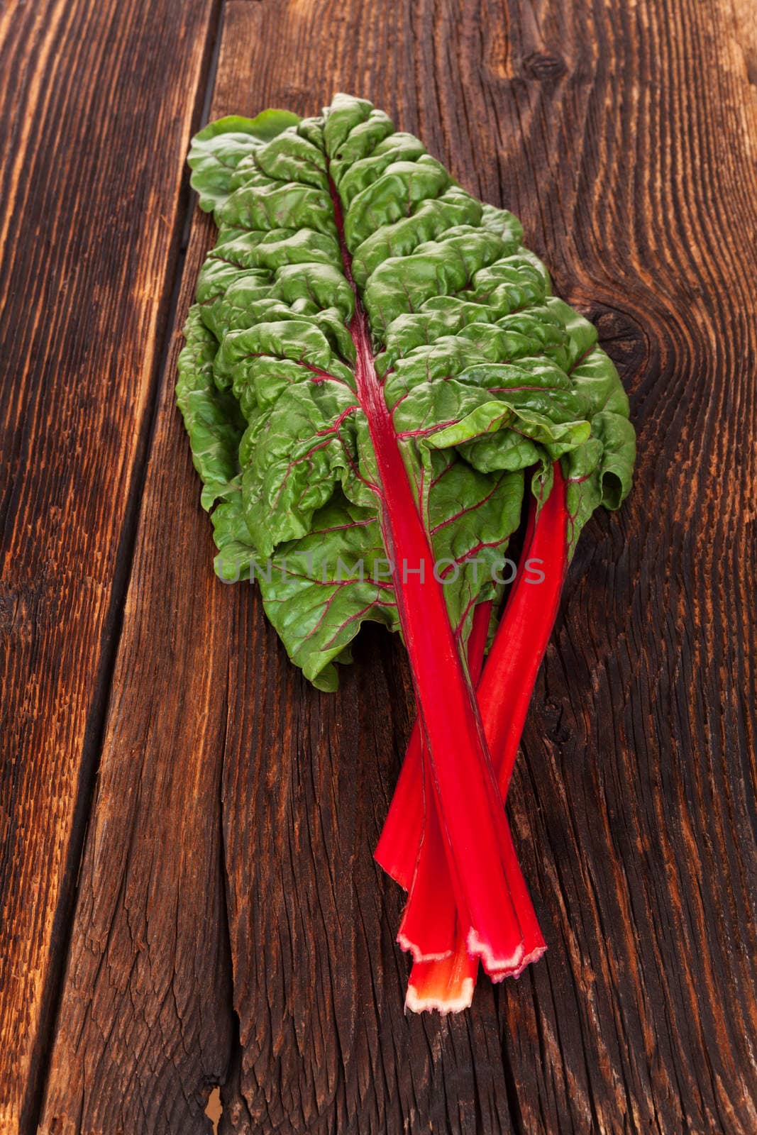 Fresh mangold leaves on rustic wooden table. Healthy vegetable eating. 