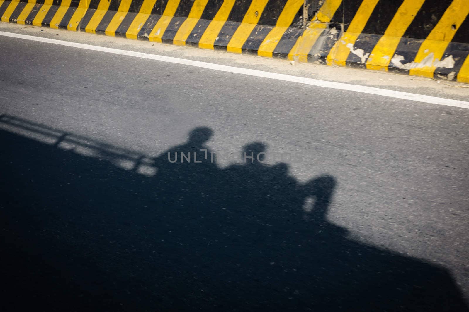 Shadow of two people traveling on a bus roof