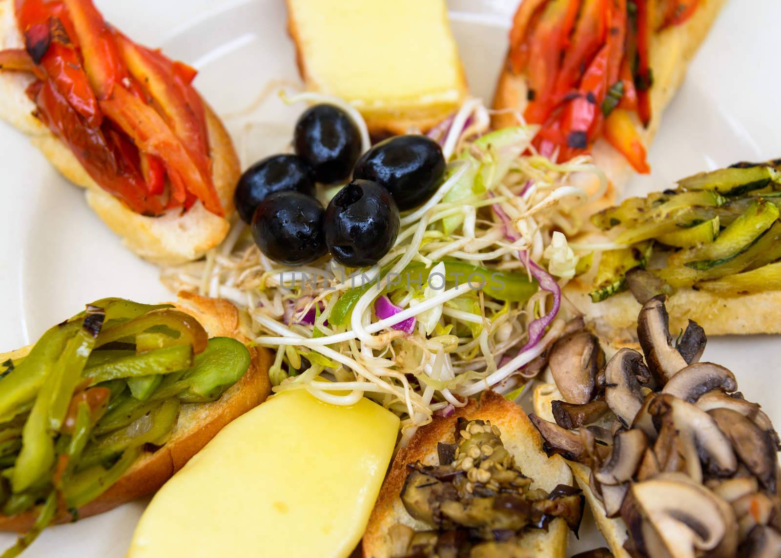 Vegetarian plate with cheese, peppers, olives and mushrooms