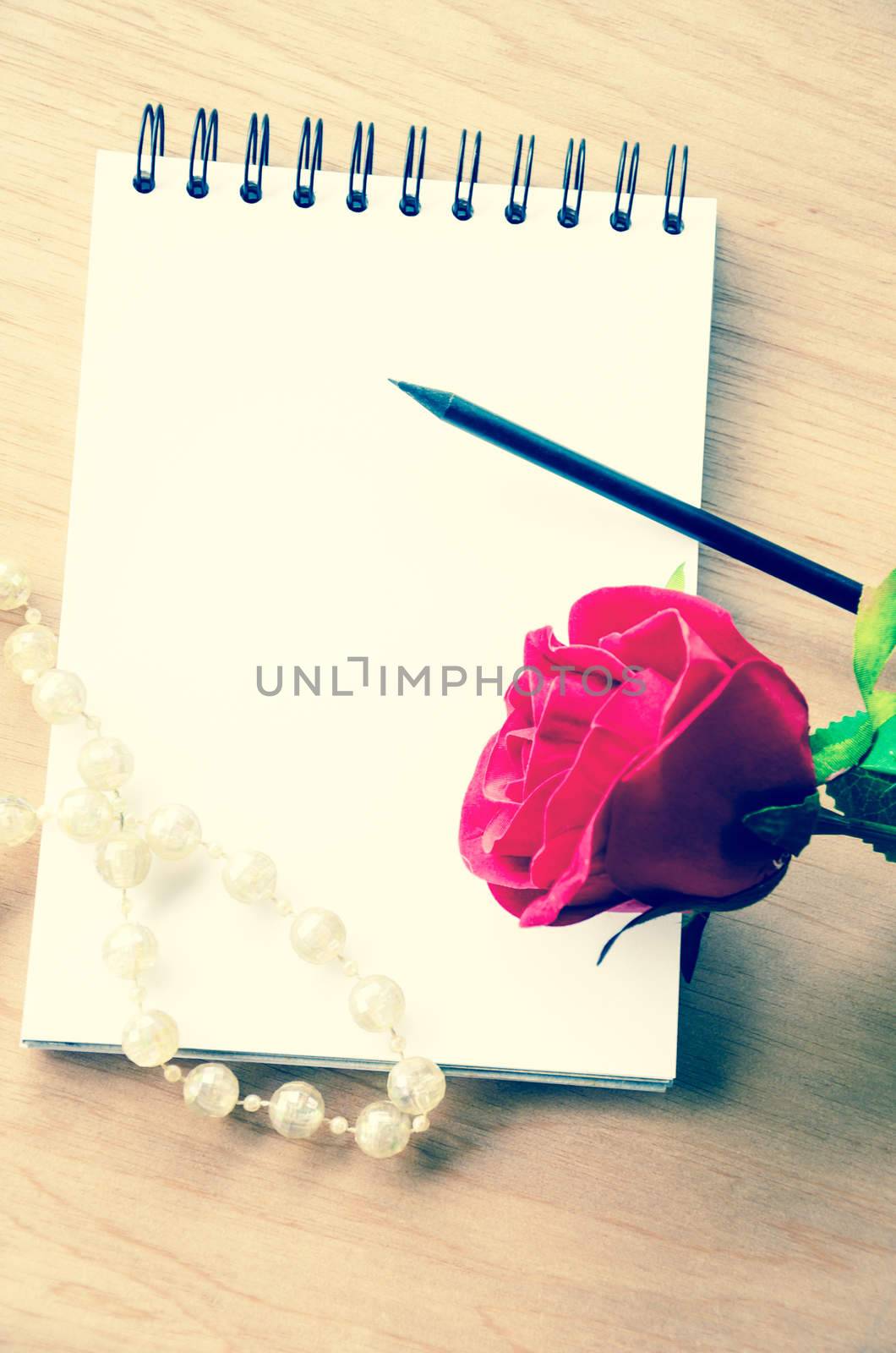 Vintage red rose and blank diary. by Gamjai