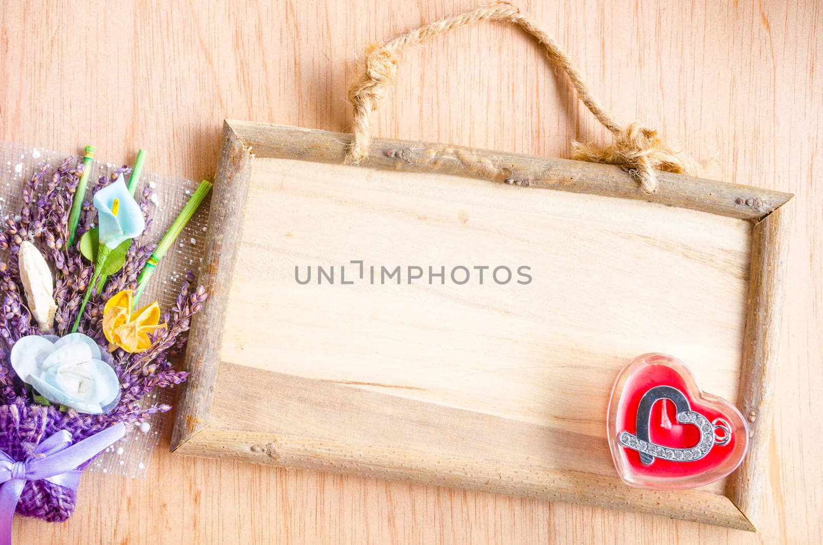 wooden photo frame and pendant in the shape of heart on wooden background.