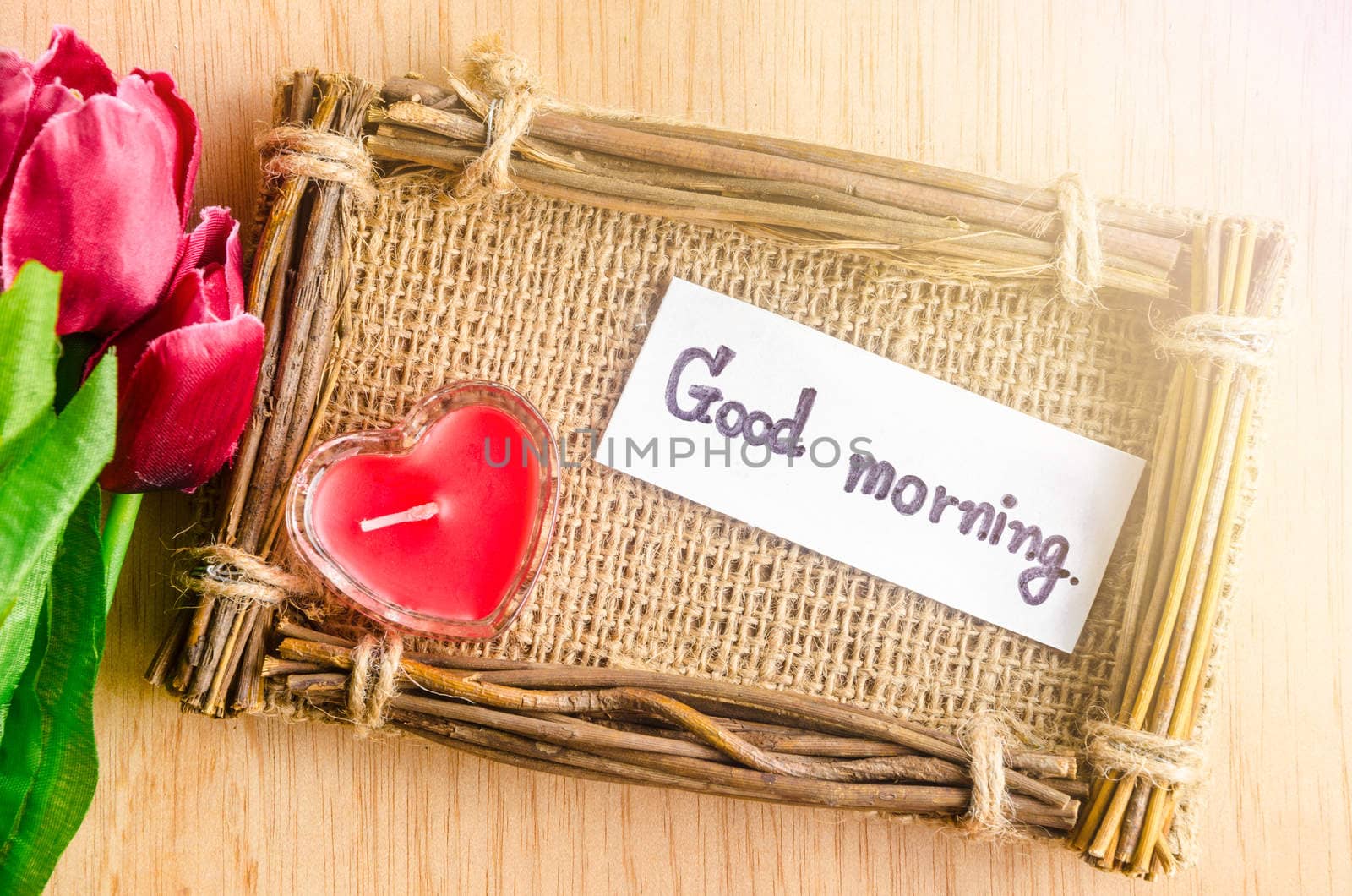 Good morning wording writing and red tulip on wooden background.