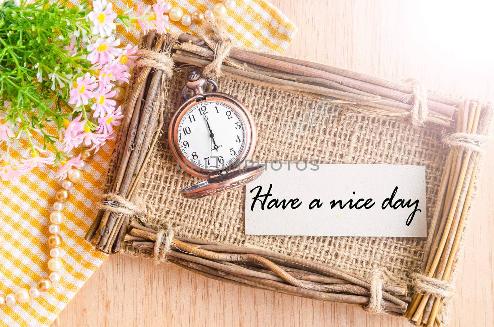 Have a nice day card and pocket watch at 6 AM with flower on wooden background.