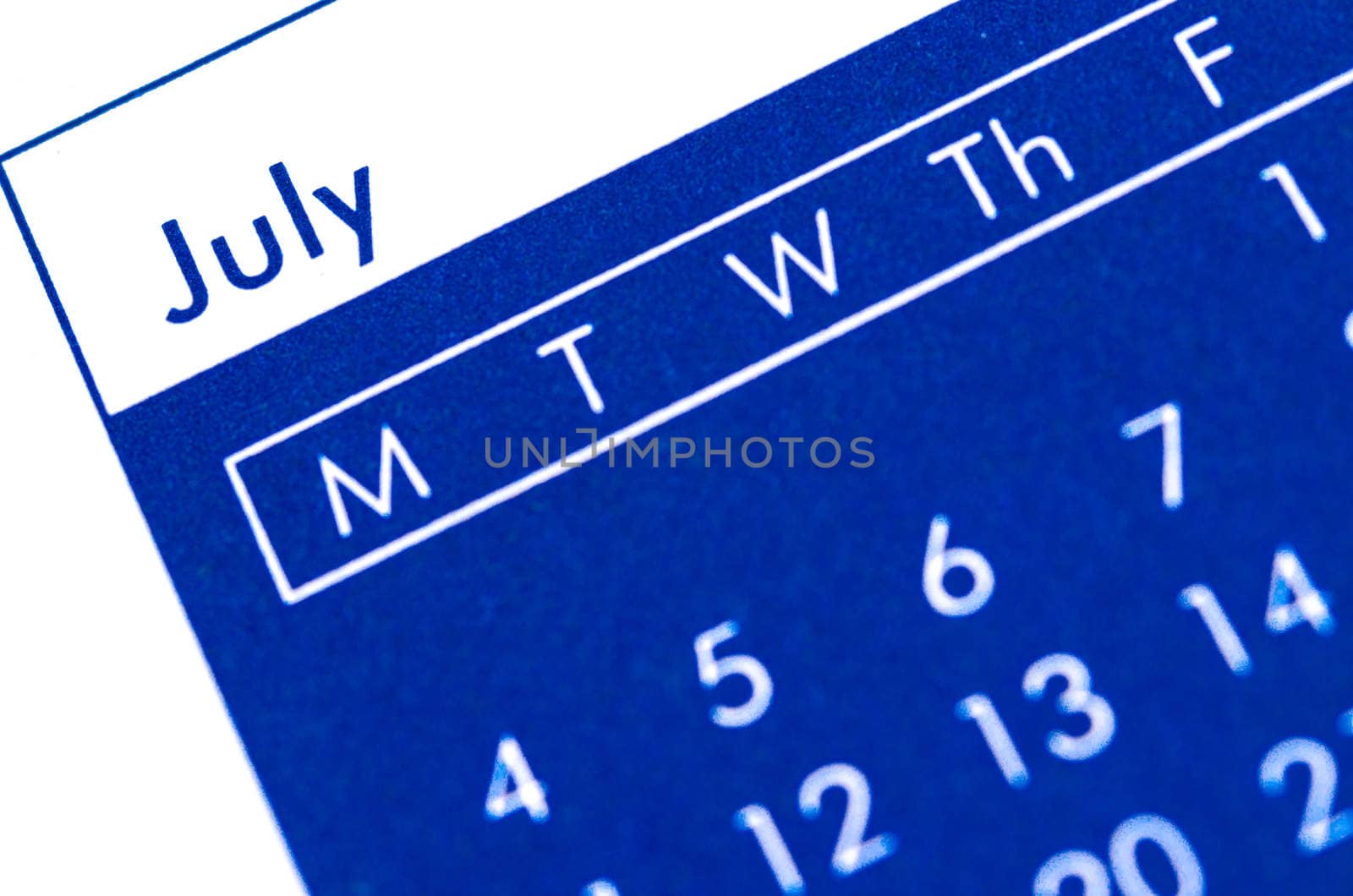 Close up of spiral bound calendar displaying month of July.