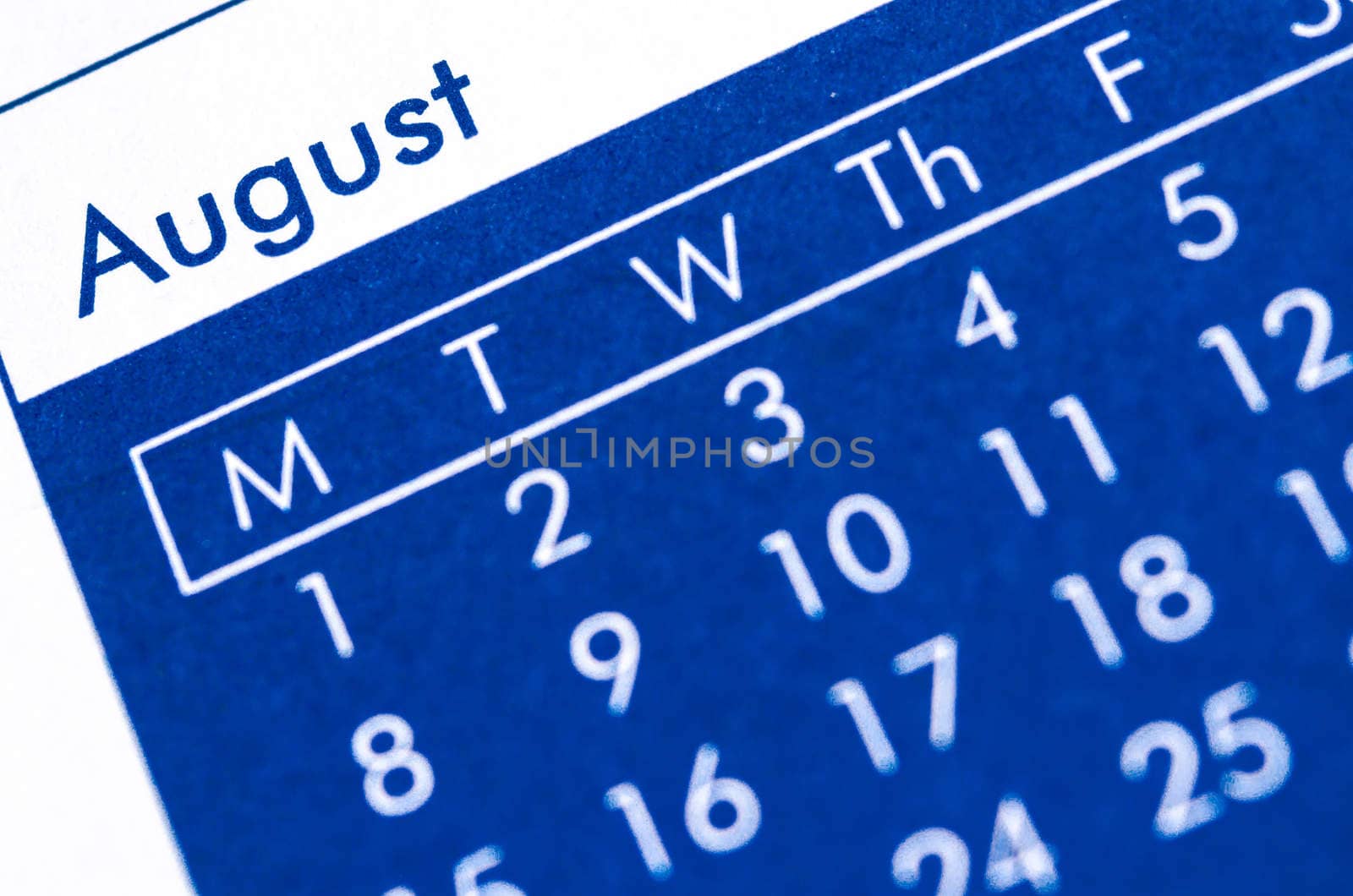 Close up of spiral bound calendar displaying month of August. by Gamjai