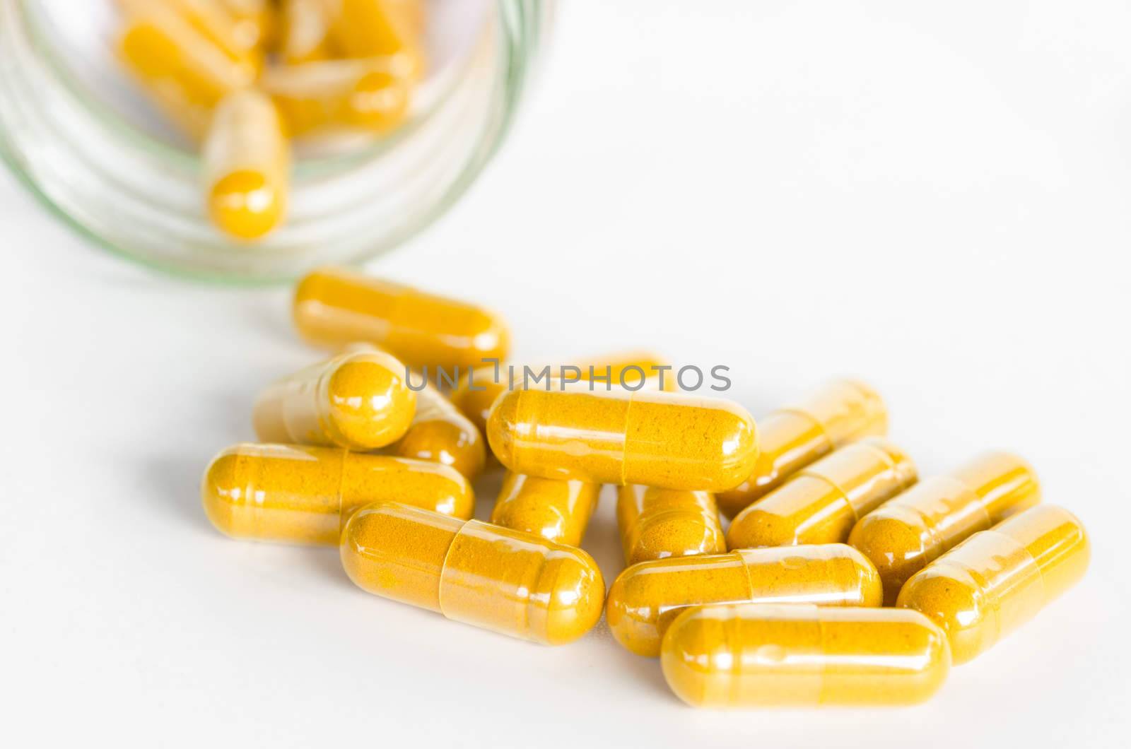 Turmeric capsules spilling out of a bottle