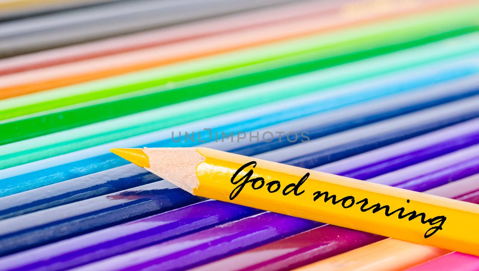 Good morning wording with yellow pencil on many color pencils background.