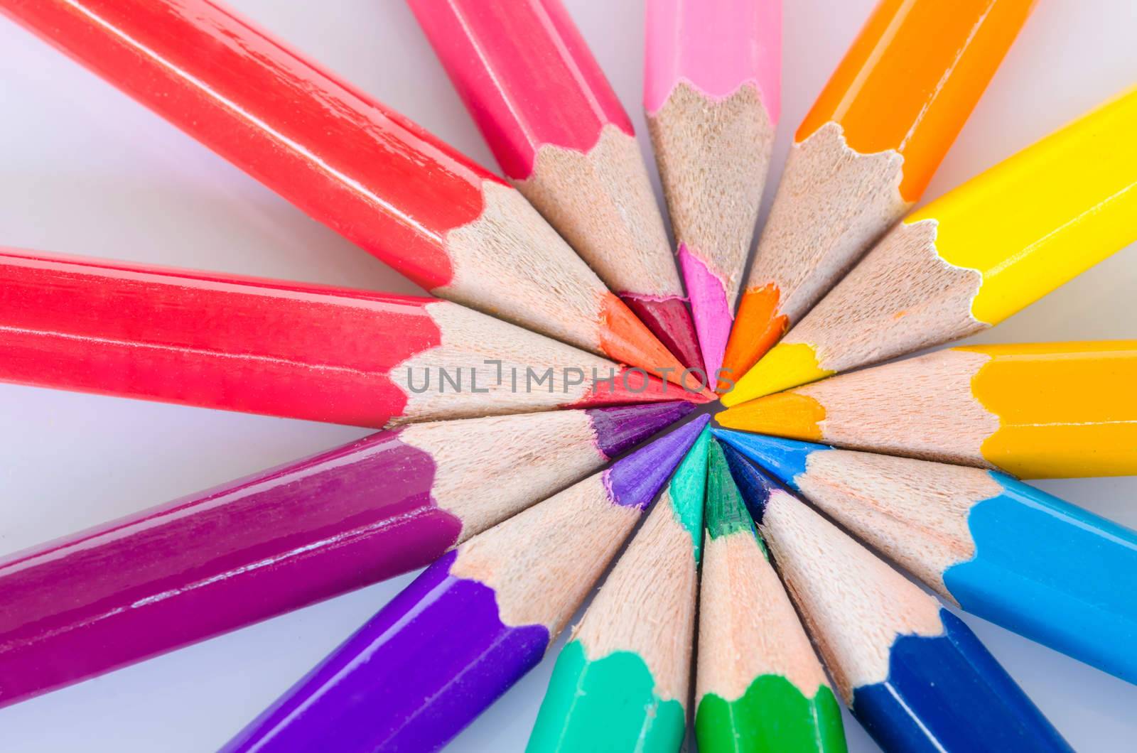 Color pencils in arrange in color wheel colors on white background