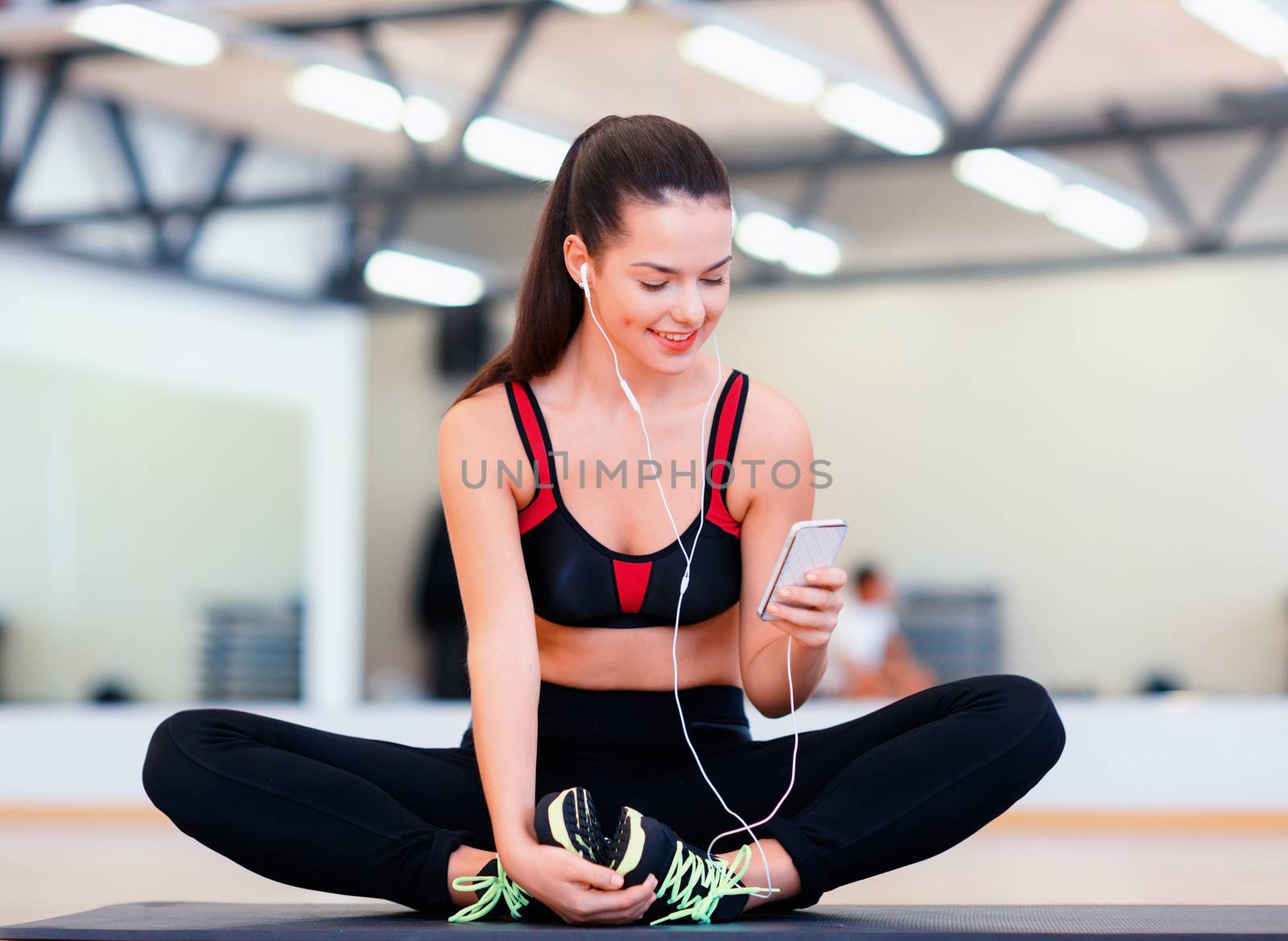 fitness, sport, training, technology and lifestyle concept - smiling woman with smartphone