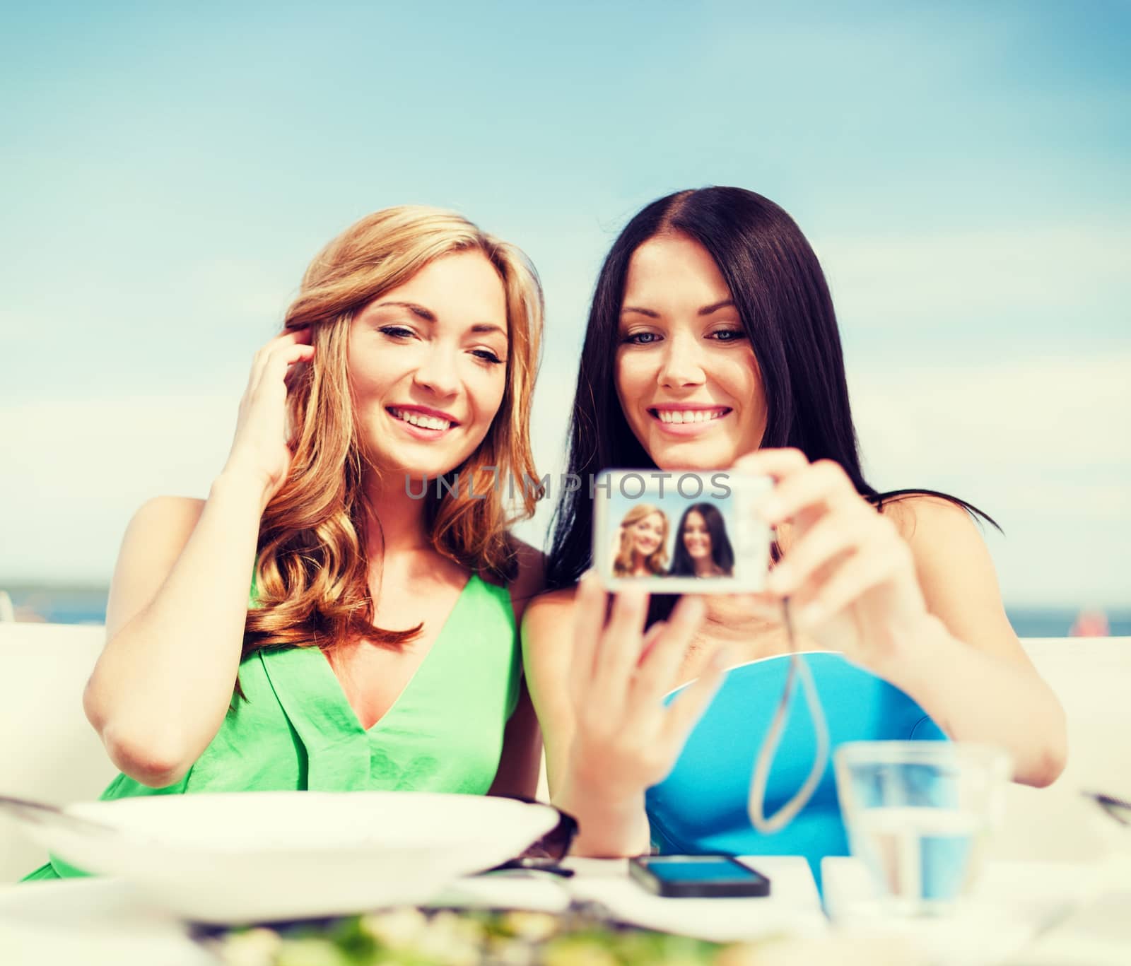 girls taking photo in cafe on the beach by dolgachov