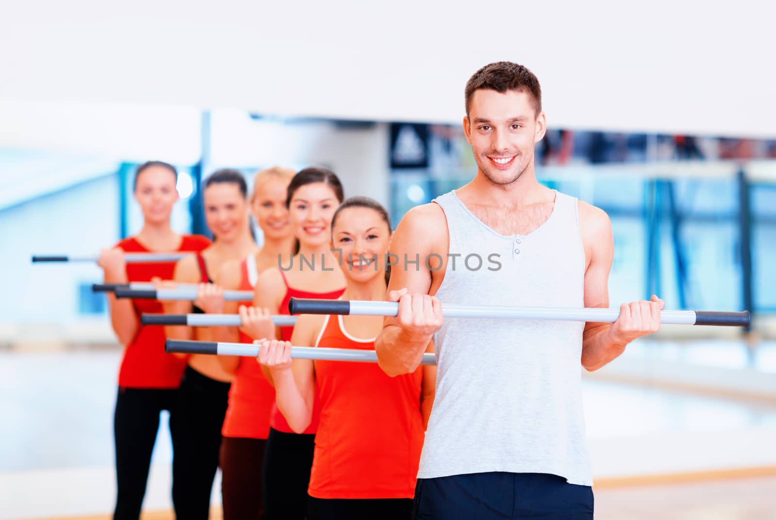 group of smiling people working out with barbells by dolgachov