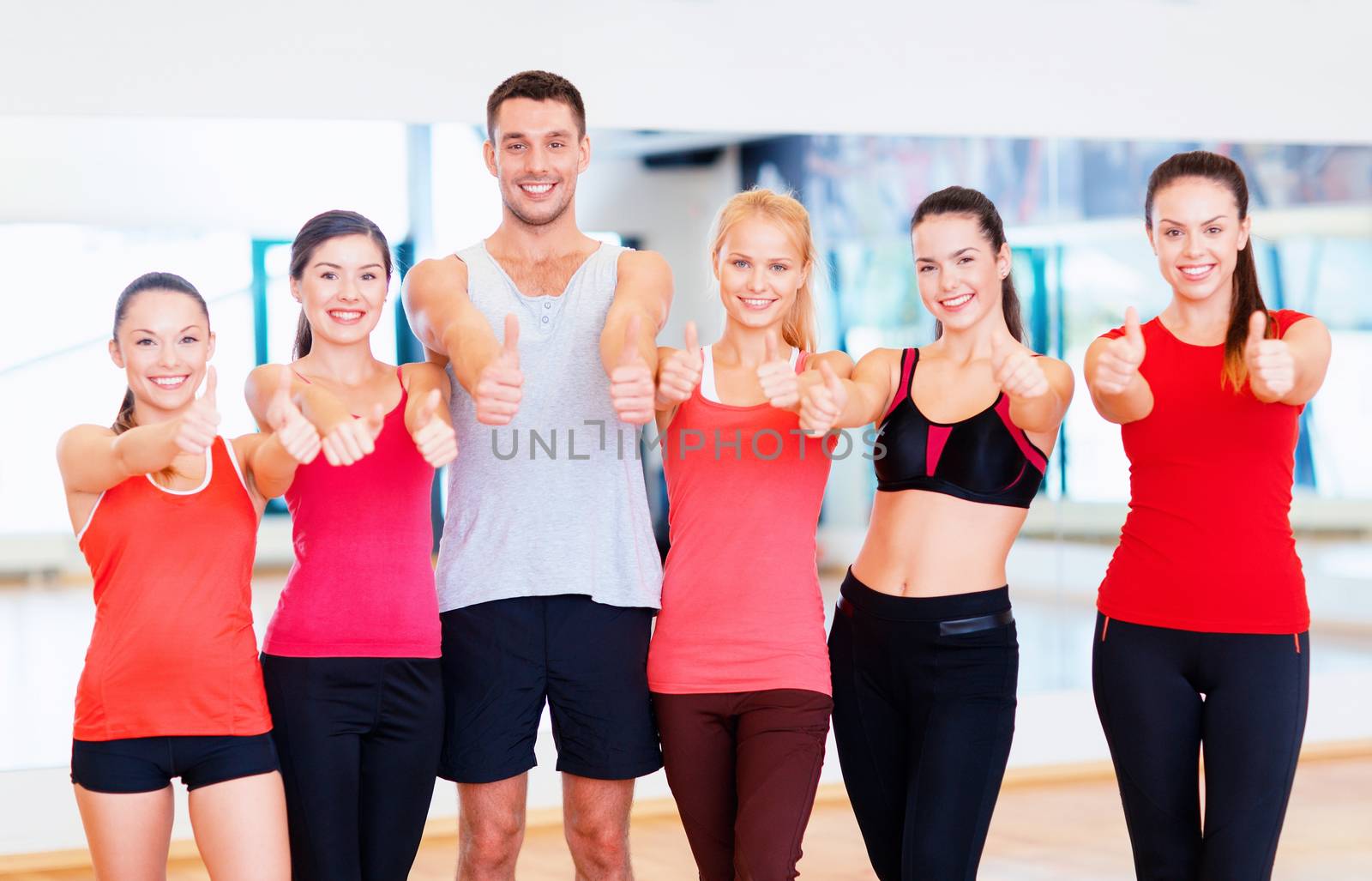 group of people in the gym showing thumbs up by dolgachov