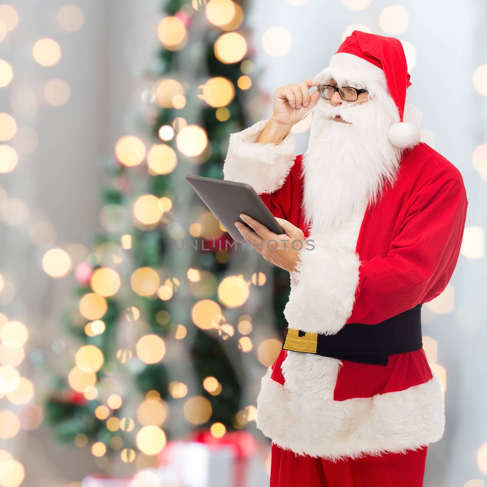 man in costume of santa claus with tablet pc by dolgachov