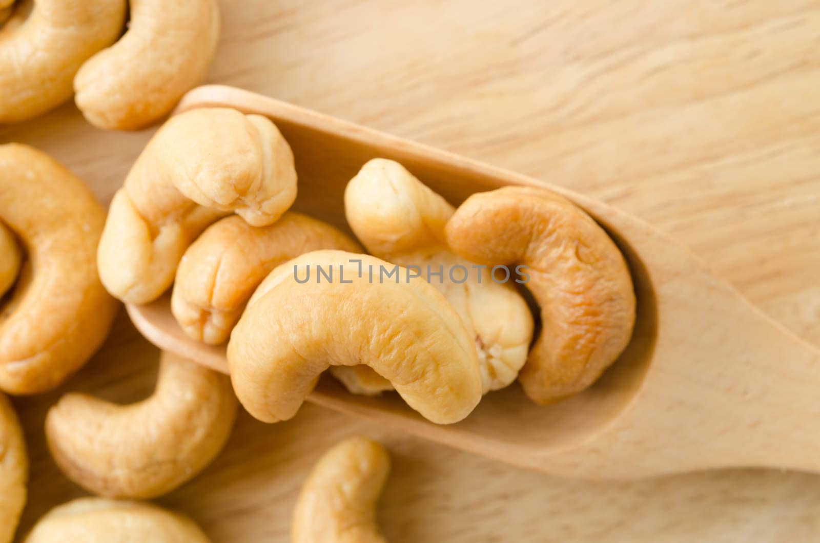 cashew nuts with salt in spoon wooden. by Gamjai