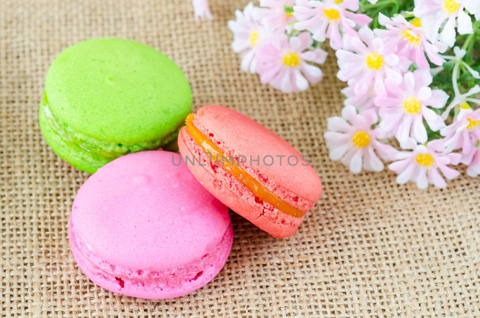 French macaroons and flower on sack background. Dessert
