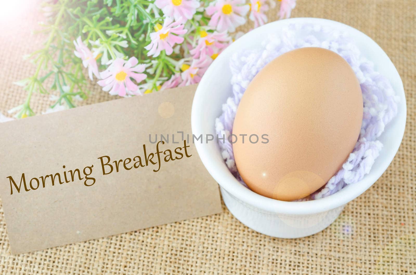 Morning breakfast and egg in white cup with flower on sack background.