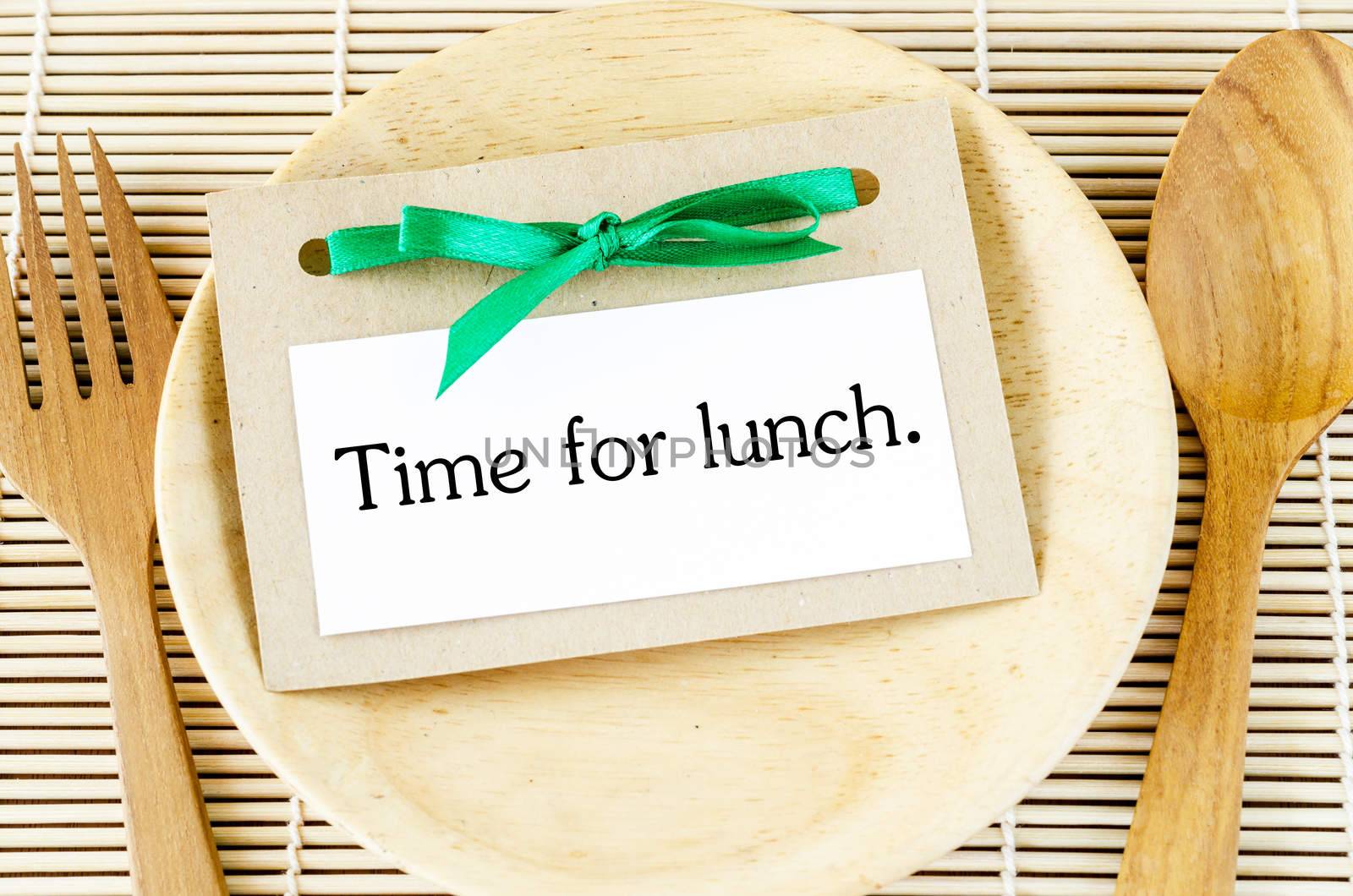 Time for lunch in card on wooden dish and spoon
