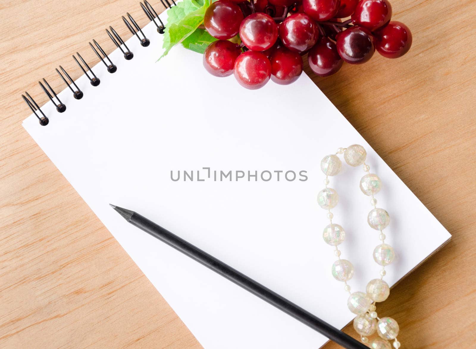 Open Blank diary and red grape on wooden background.