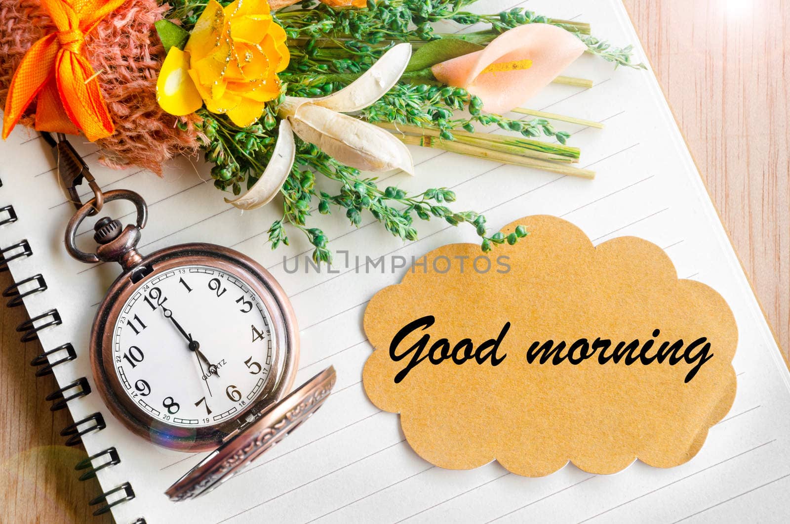 Good morning word. Blank brown tag and pocket watch on diary with flower.