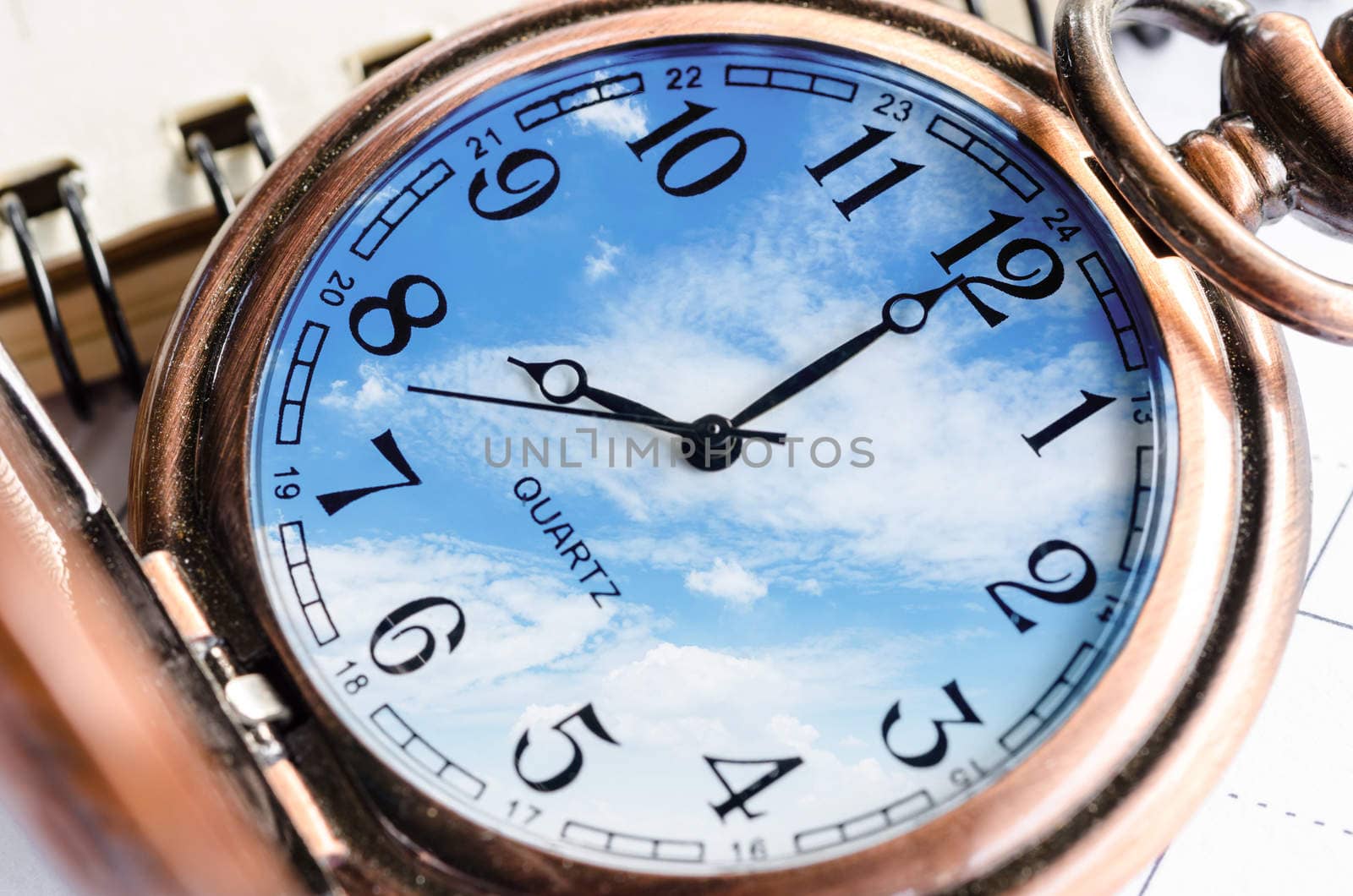 Vintage Clock face in blue sky and diary.