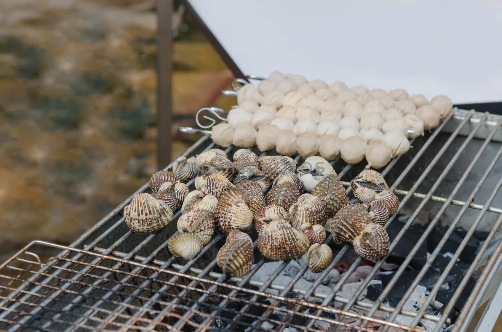 close up seafood bbq ,  cockles on flaming grill