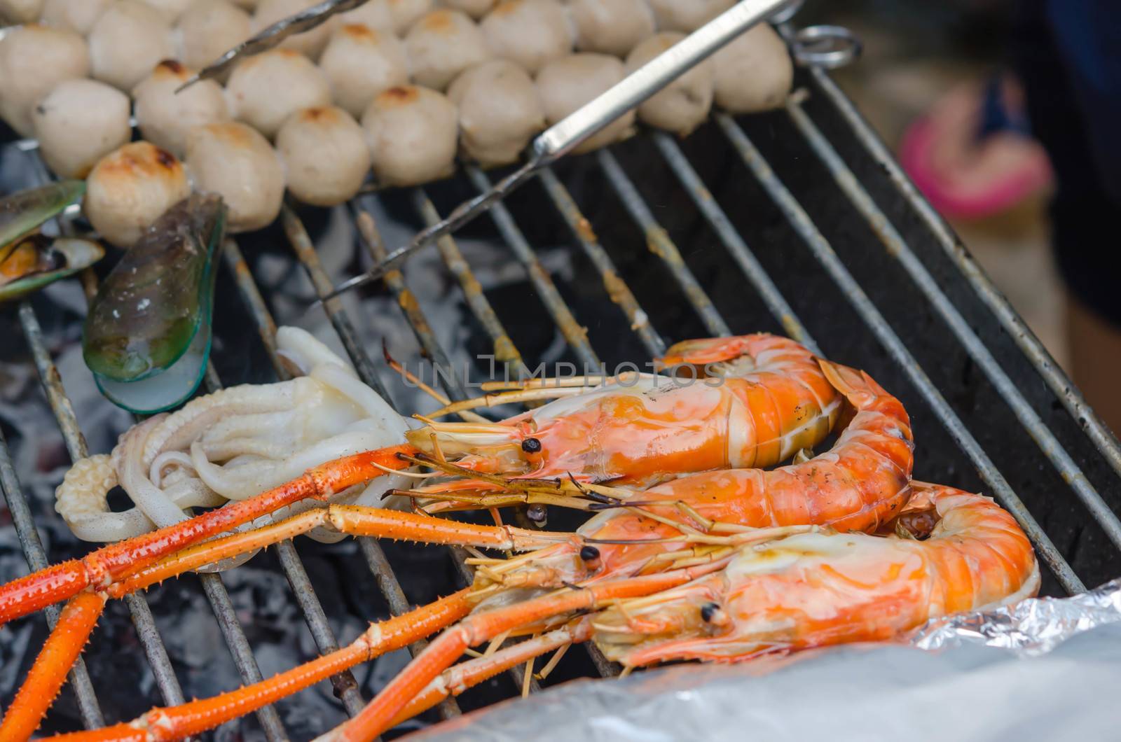 Grilled prawns , squid on flaming grill , seafood bbq