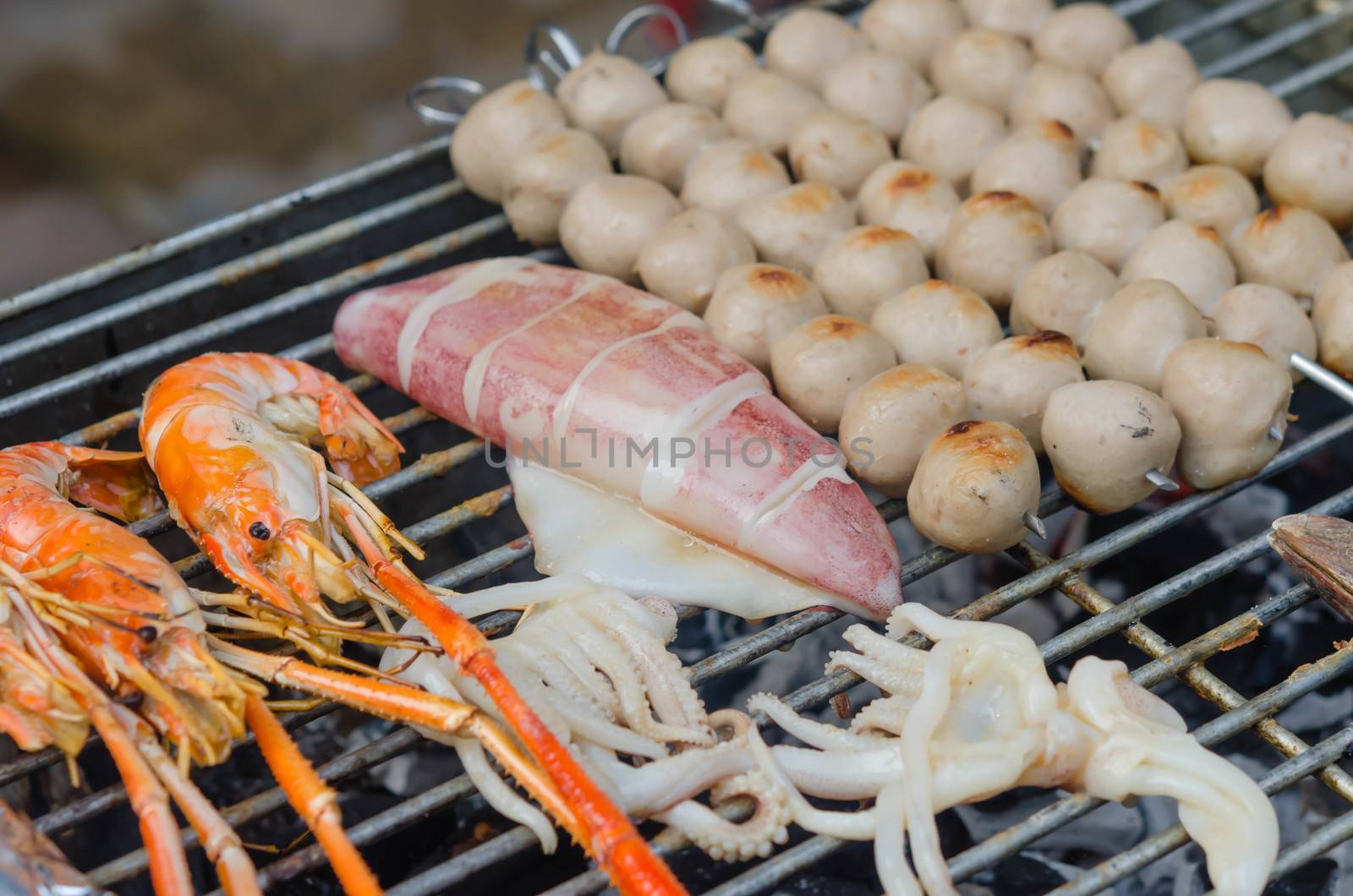 Grilled prawns , squid on flaming grill , seafood bbq