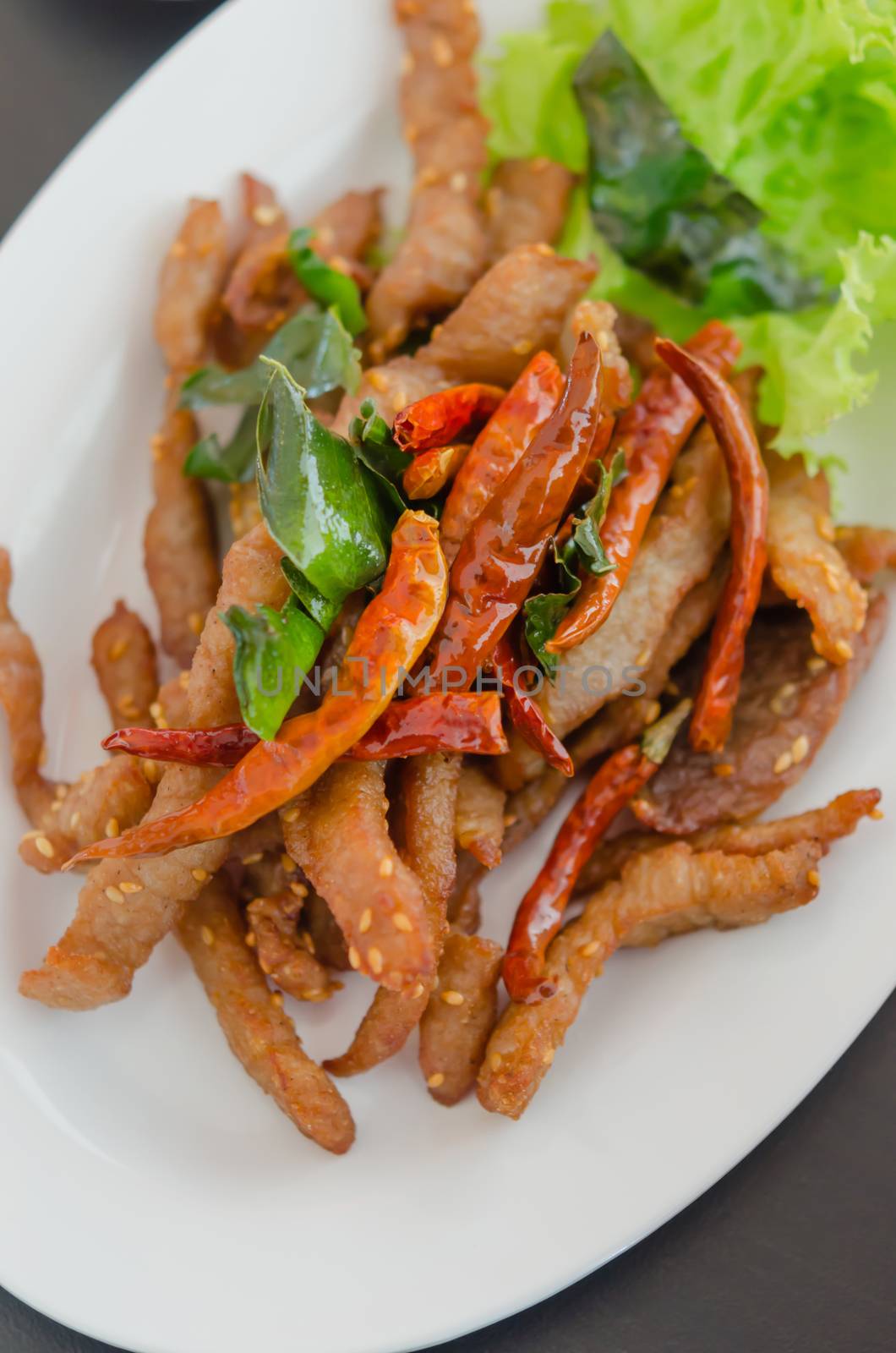 Closeup of fresh fried meat with sesame and chili
