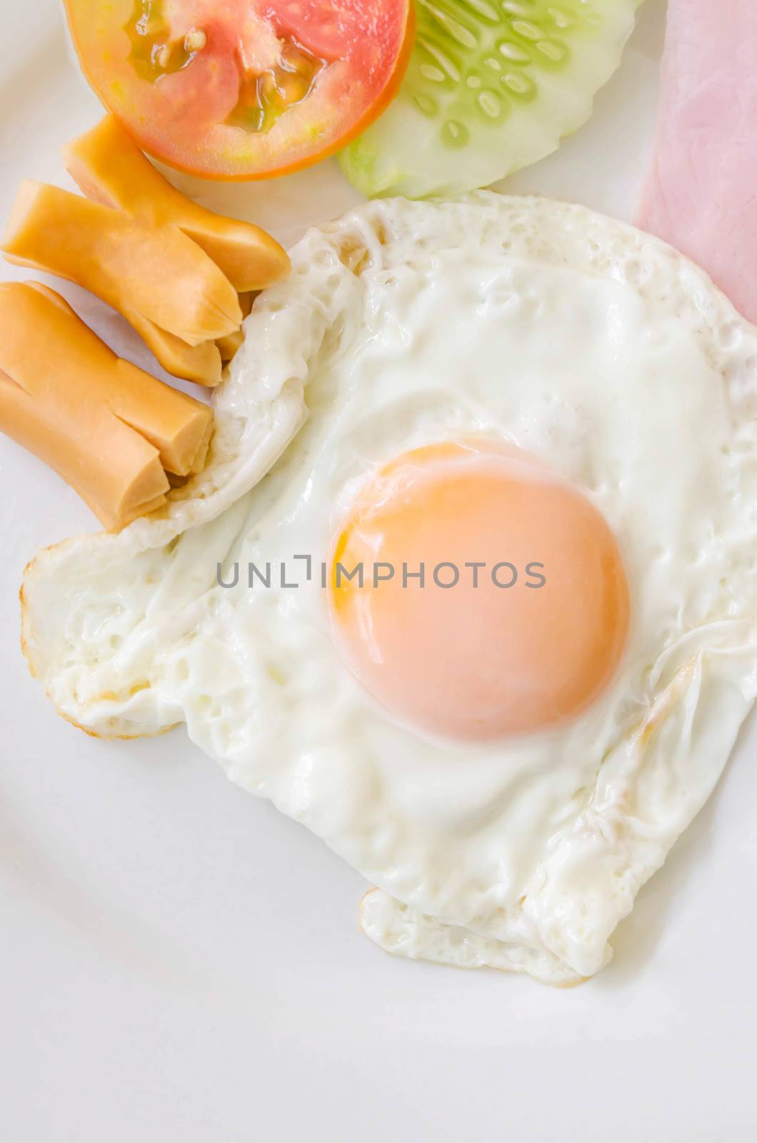 Fried eggs and sausage on a white  plate