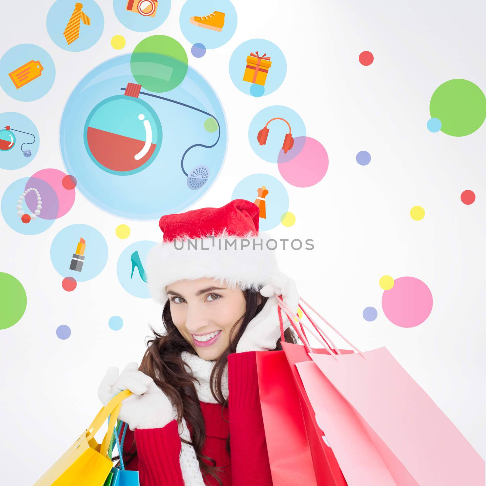 Festive brunette in winter wear holding shopping bags against dot pattern