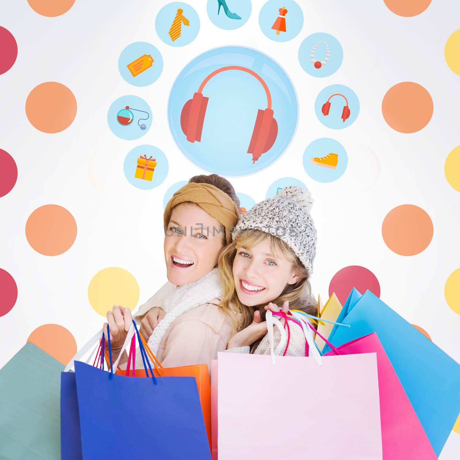 Beautiful women holding shopping bags looking at camera  against colorful polka dot pattern 