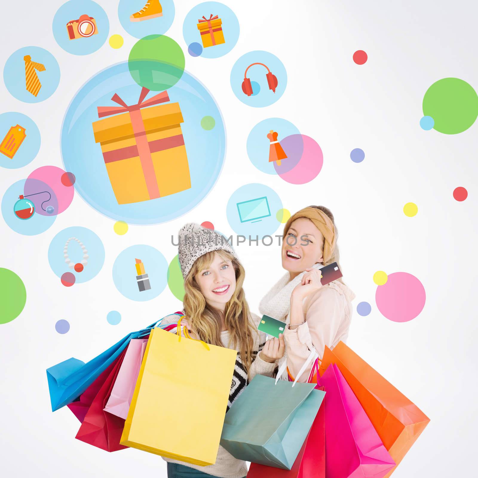 Beautiful women holding shopping bags looking at camera  against dot pattern