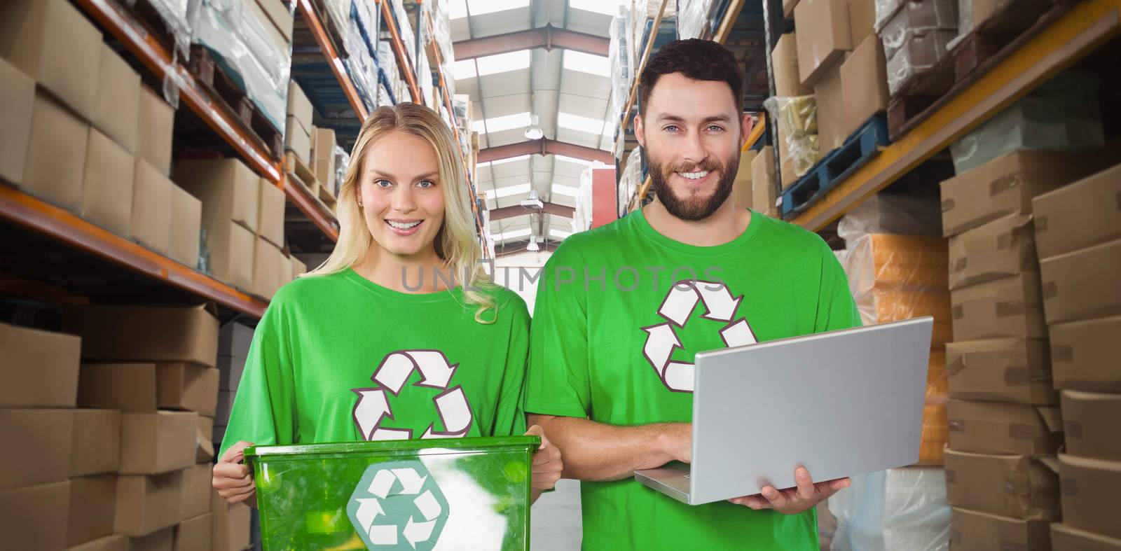 Portrait of smiling volunteers in recycling symbol tshirts  against shelves with boxes in warehouse