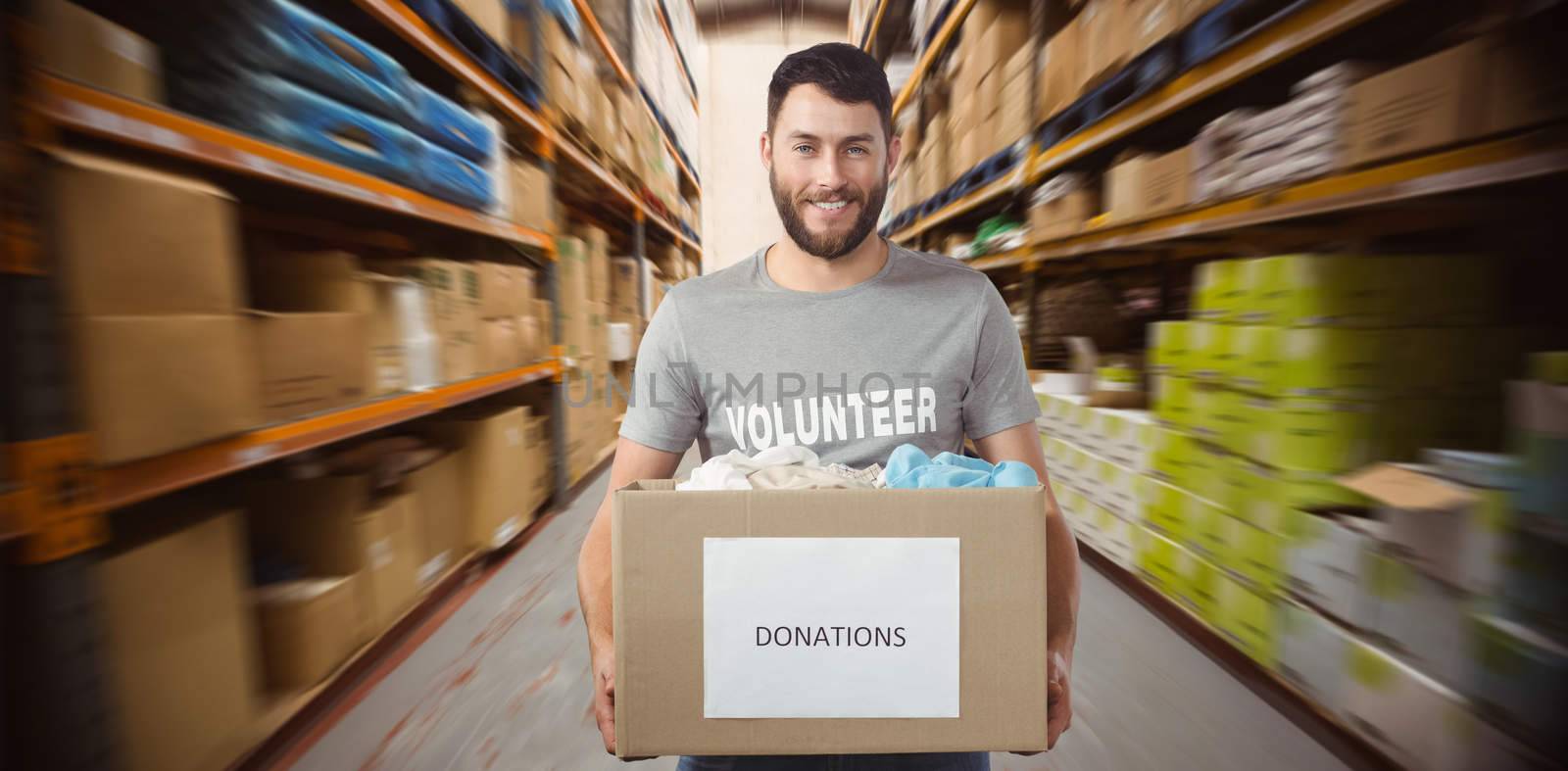 Composite image of portrait of man holding clothes donation box in office by Wavebreakmedia