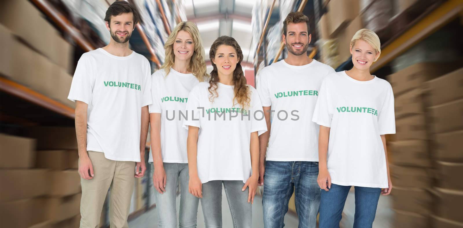 Group portrait of happy volunteers against shelves with boxes in warehouse
