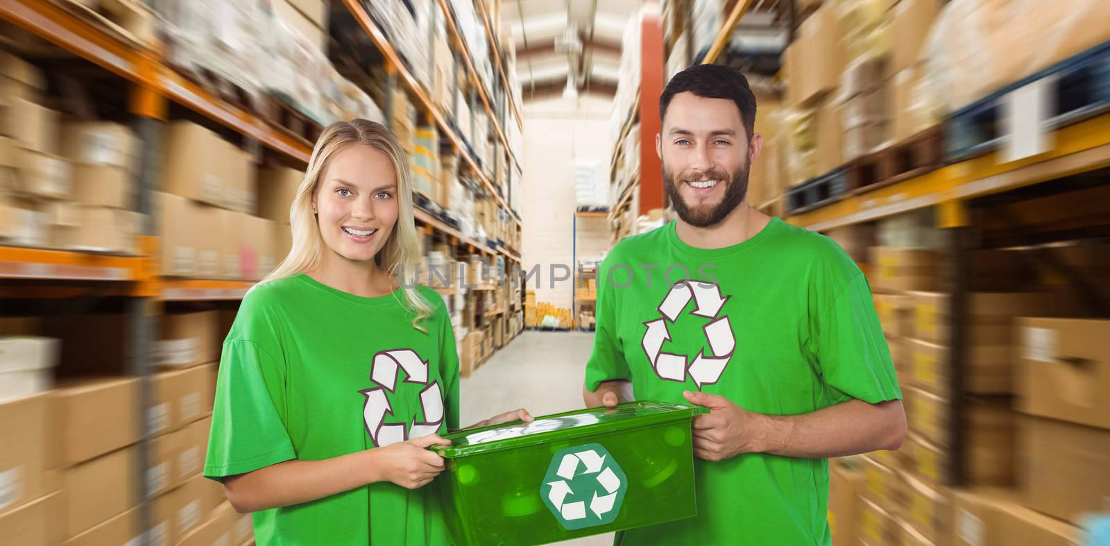 Portrait of smiling volunteers carrying recycling container  against shelves with boxes in warehouse