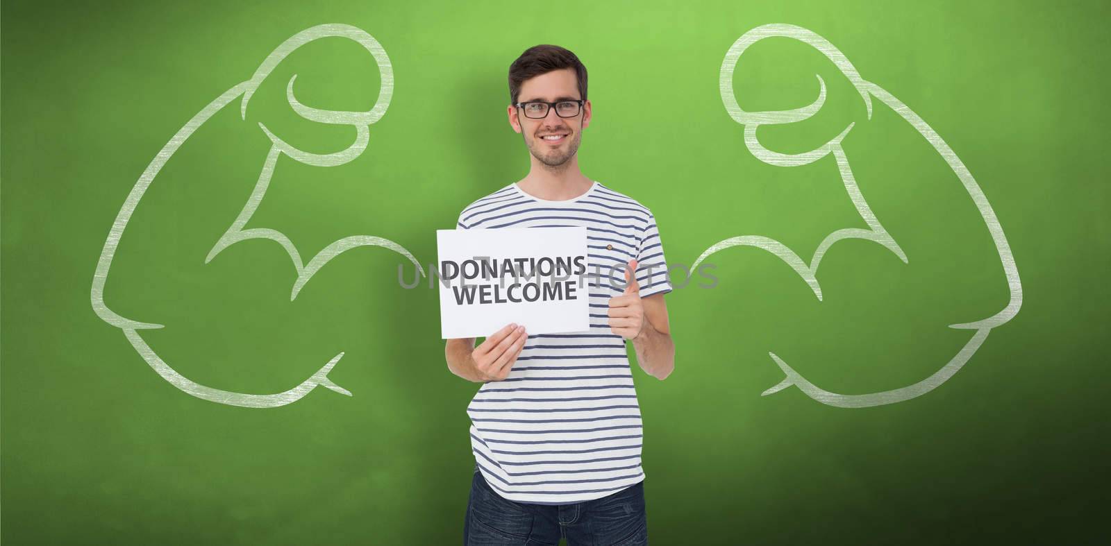 Man holding a donation welcome note while gesturing thumbs up against green chalkboard