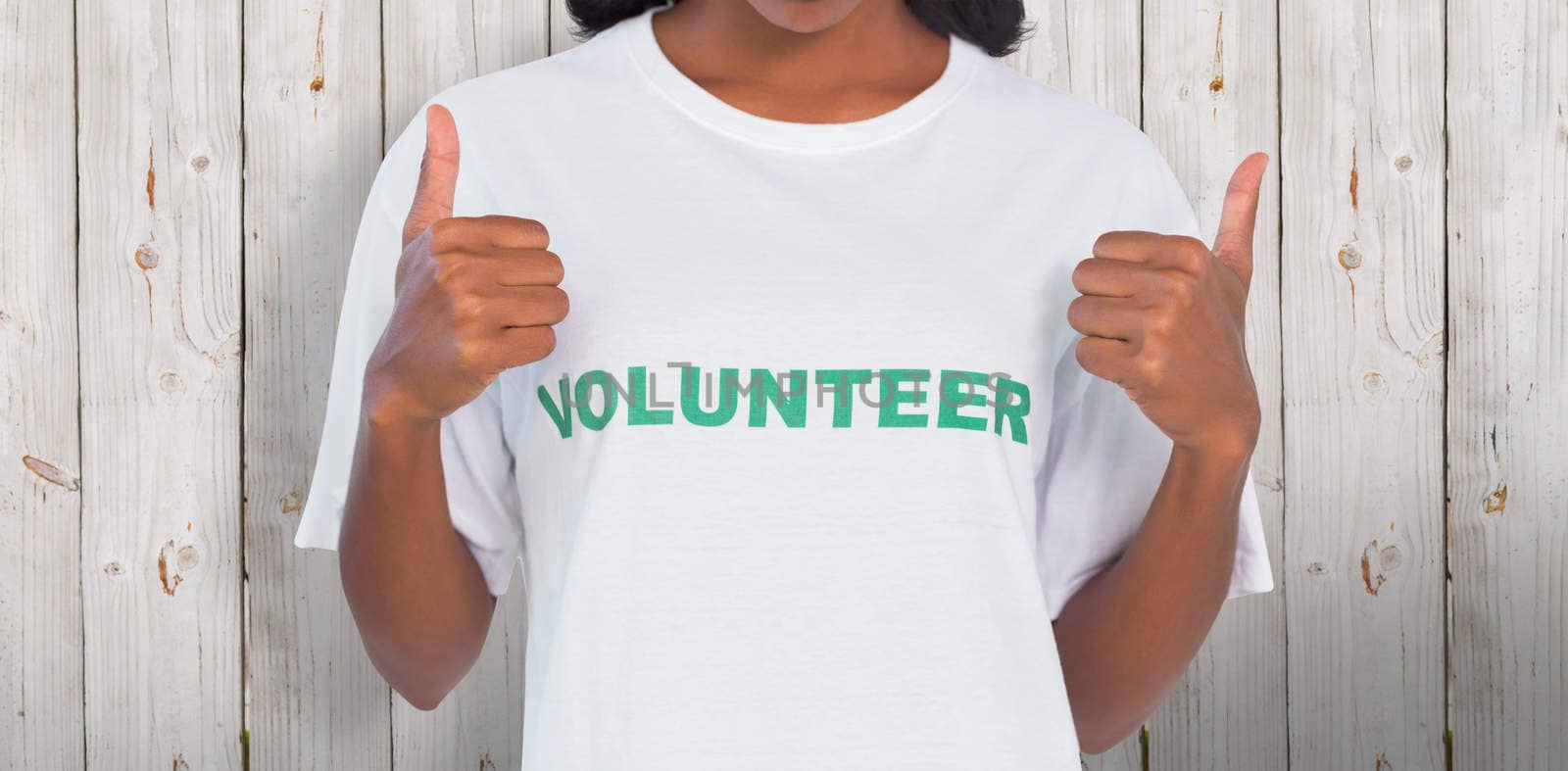 Composite image of woman wearing volunteer tshirt and giving thumbs up by Wavebreakmedia